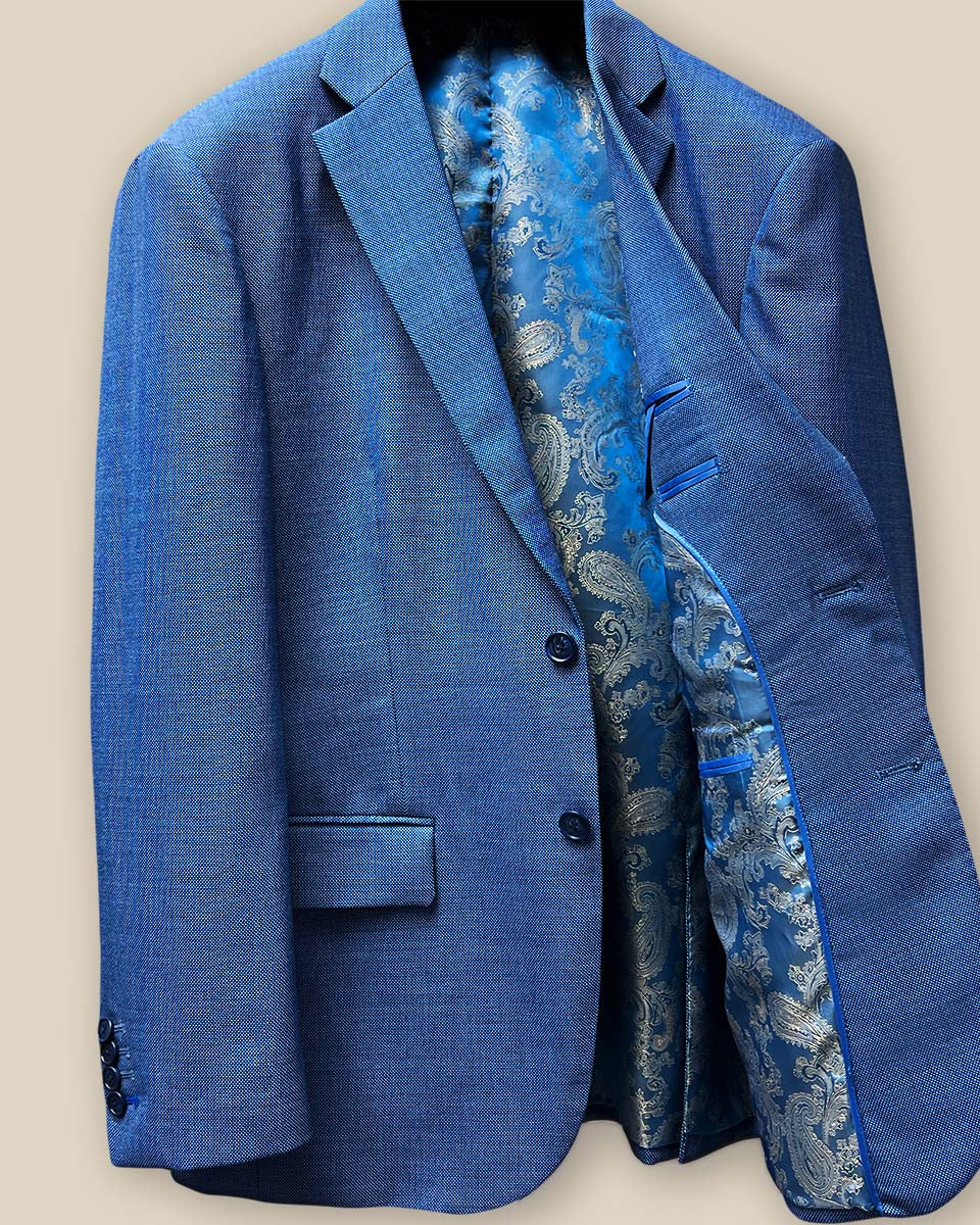 Interior view of light blue suit jacket showing blue and gold paisley flash lining on left side