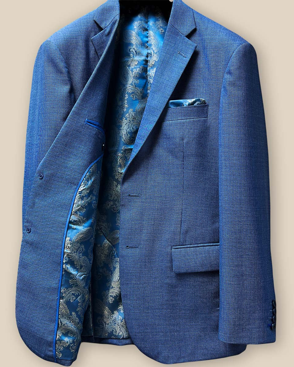 Interior view of light blue suit jacket showing blue and gold paisley flash lining on right side