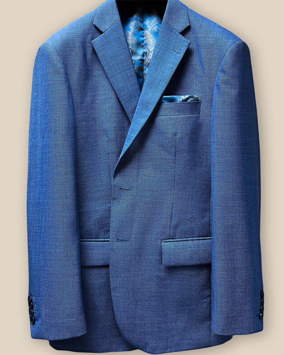 Close-up of light blue birdseye suit jacket sleeve with royal blue accent buttonhole
