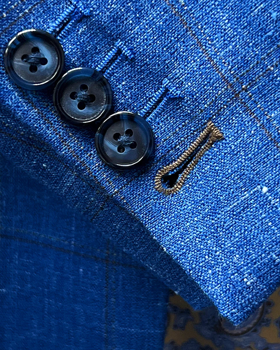 Working sleeve buttonholes with chocolate brown contrast stitching demonstrating authentic custom tailoring detail