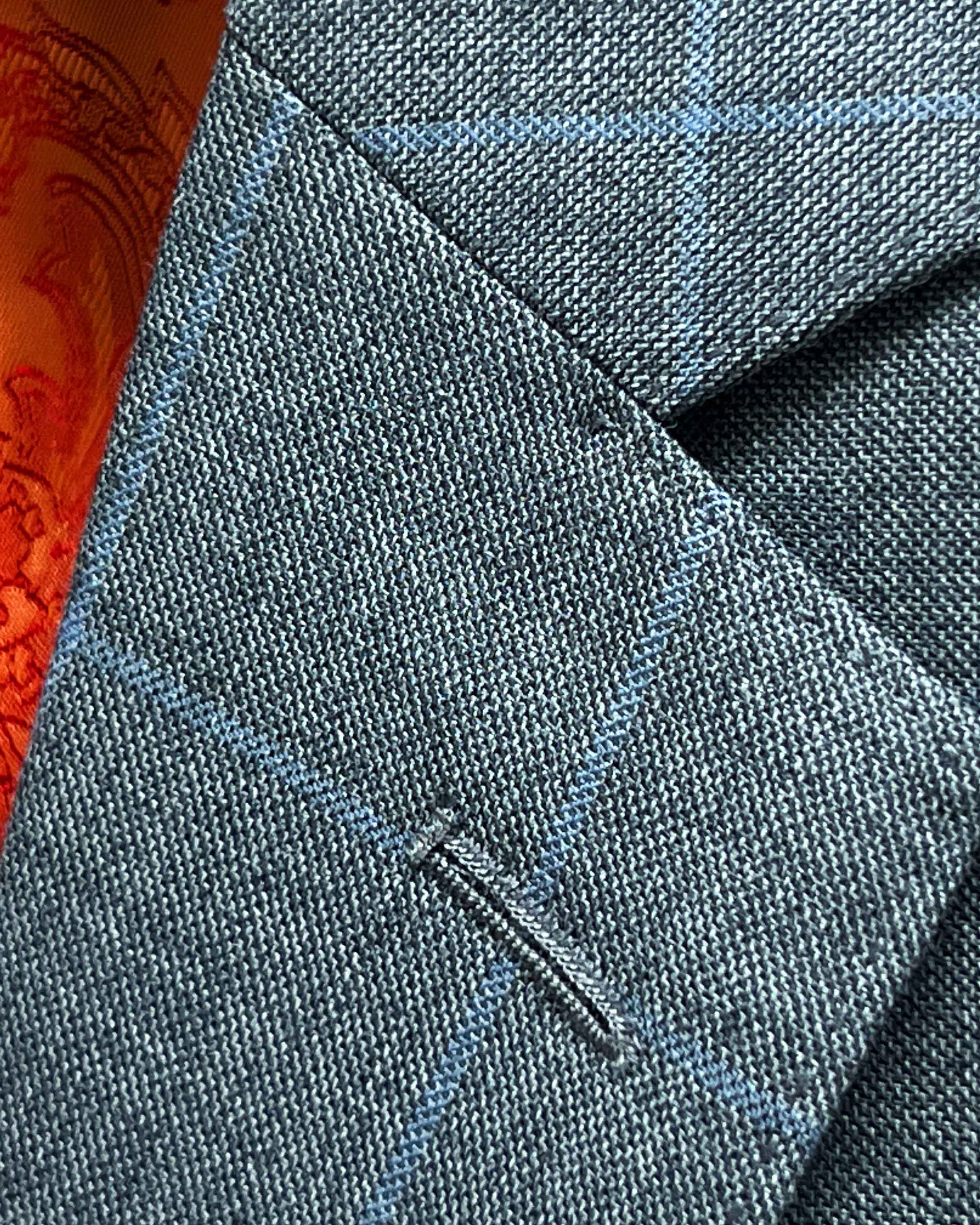 Classic notch lapel detail on light gray with light blue windowpane sport coat showing hand pick stitching and windowpane pattern