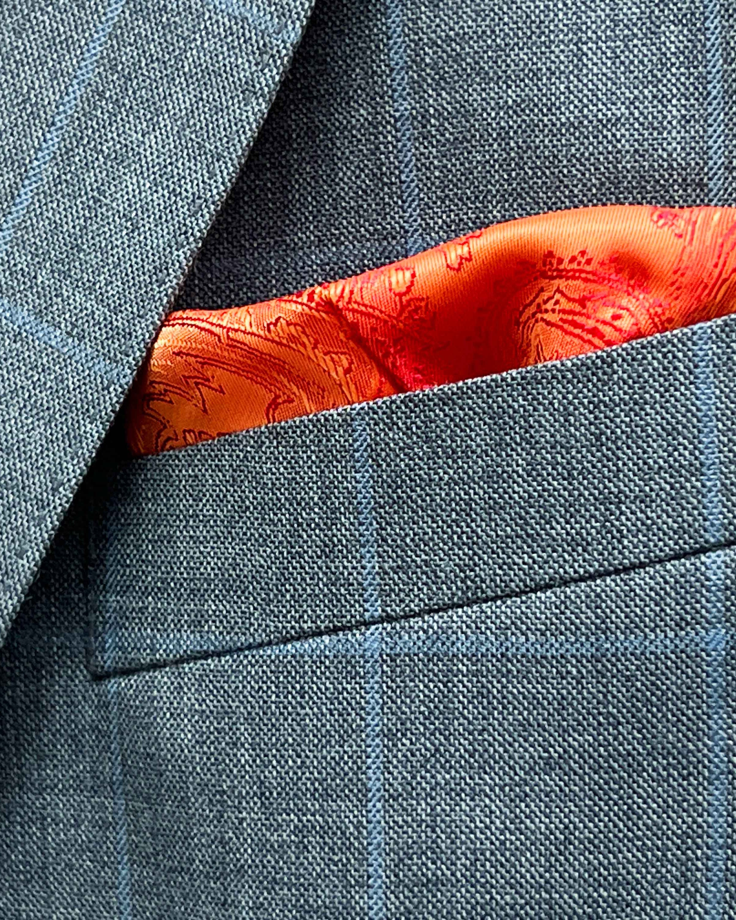 Breast pocket of light gray with light blue windowpane sport coat with built-in pocket square holder and hand-finished edges