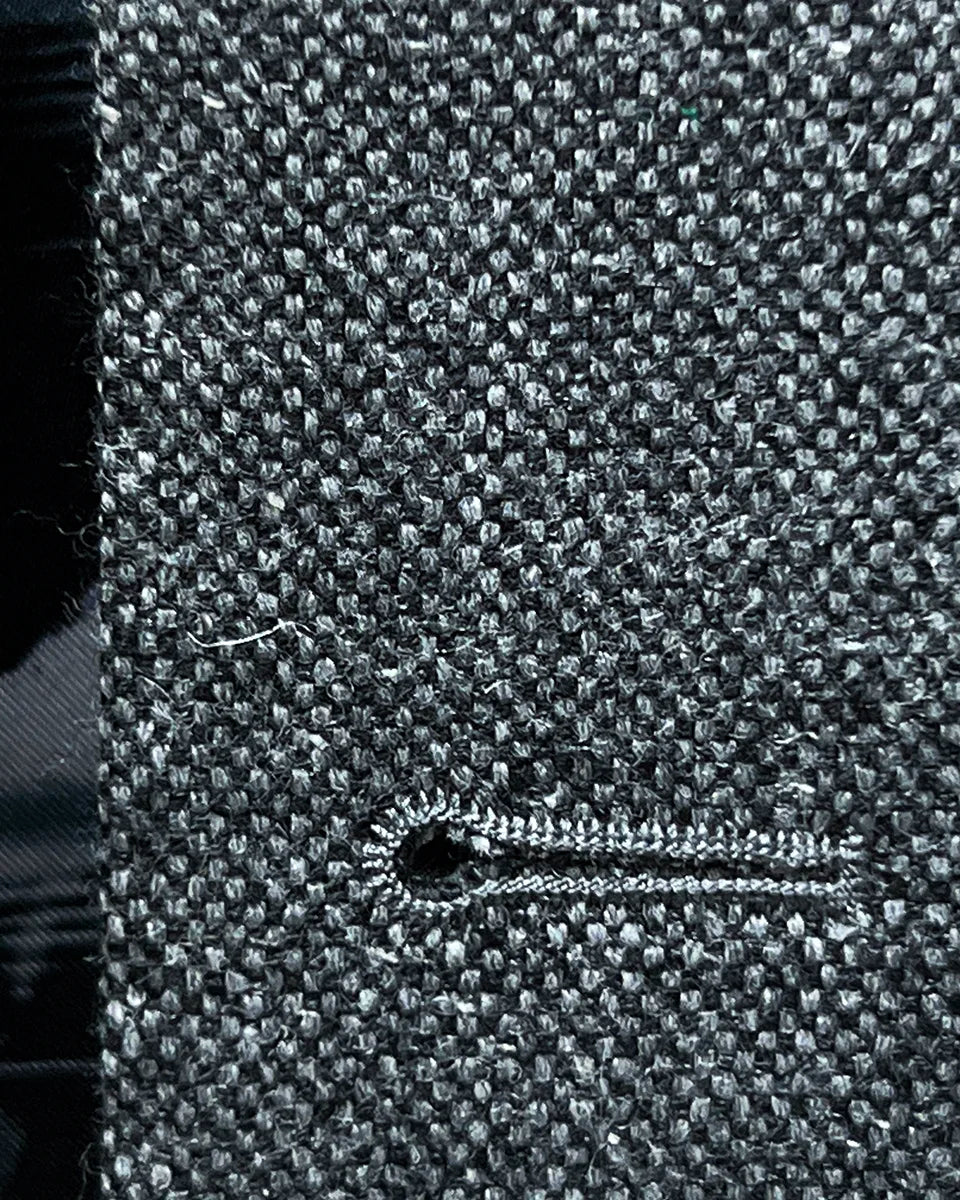 Macro shot of black contrast buttonhole stitching showing precise handwork detail