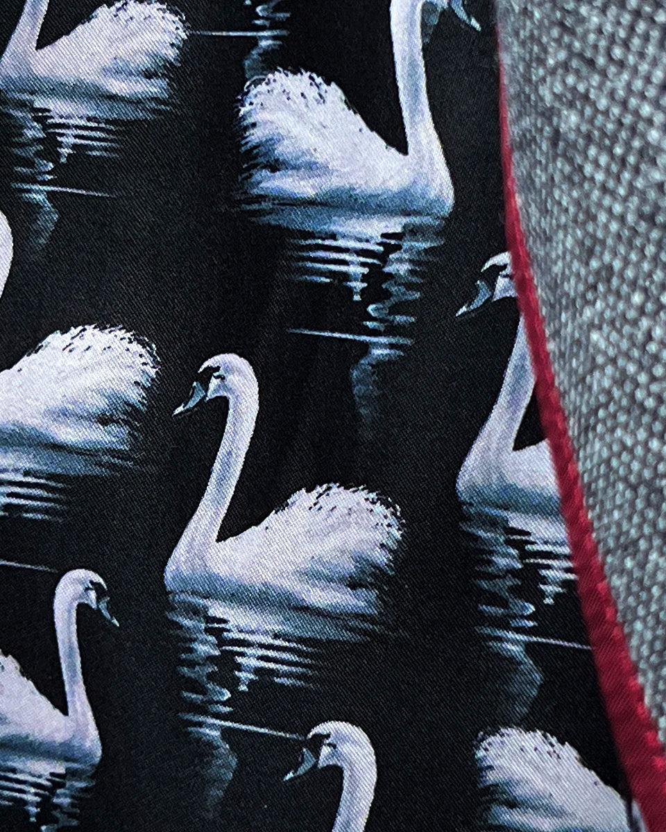 Detail of black swan-patterned lining with maroon piping accent showing through front vents