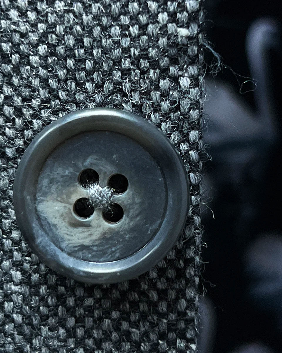 Macro shot of light grey horn marble buttons showing natural variations and luxury detail