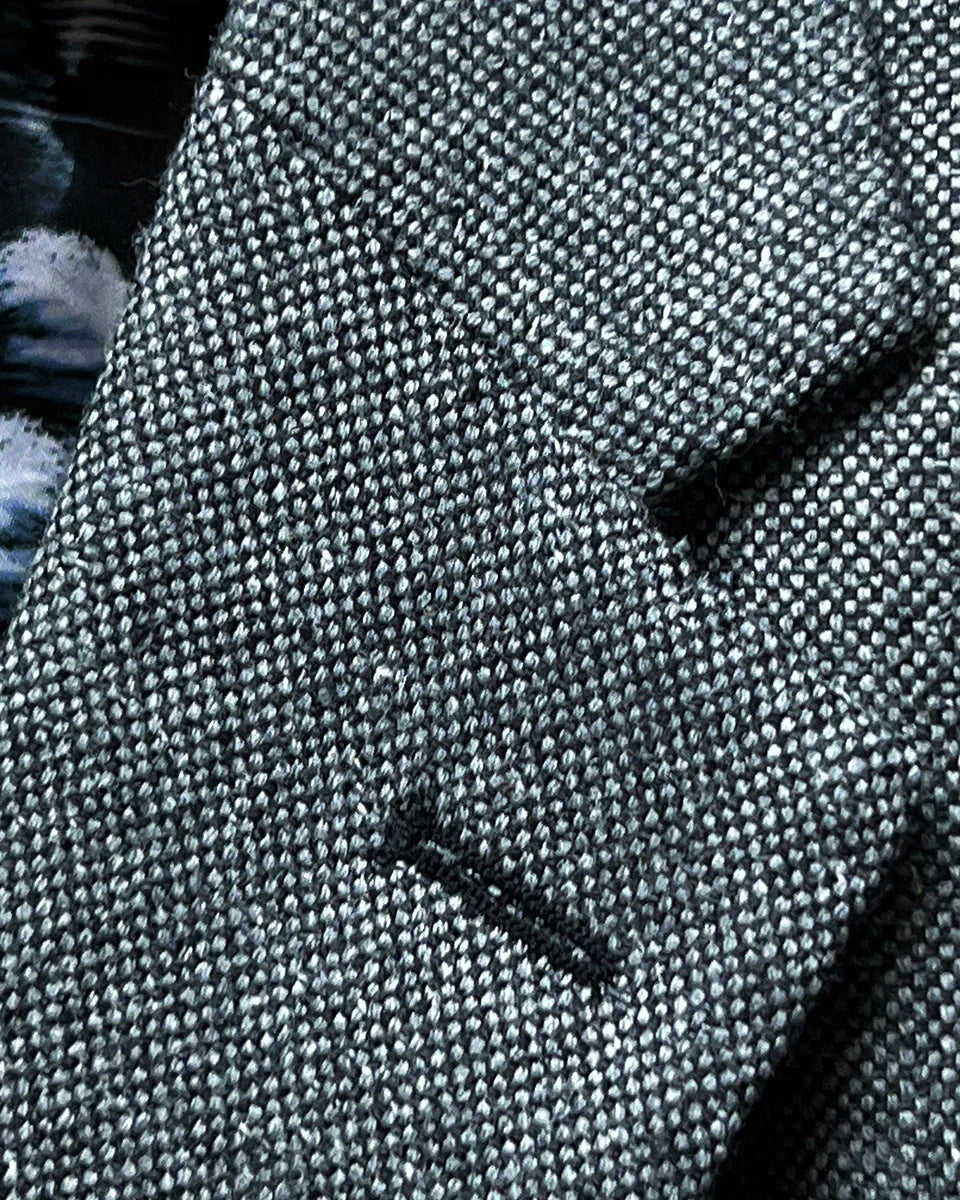 Close-up of notch lapel construction with black contrast buttonhole and pick stitching detail