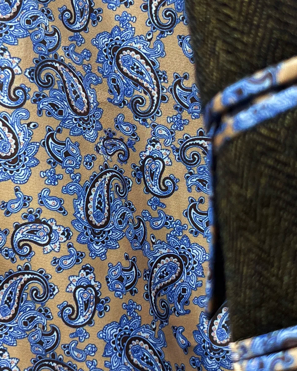Dramatic view of vibrant blue and gold paisley lining creating striking contrast against medium brown exterior