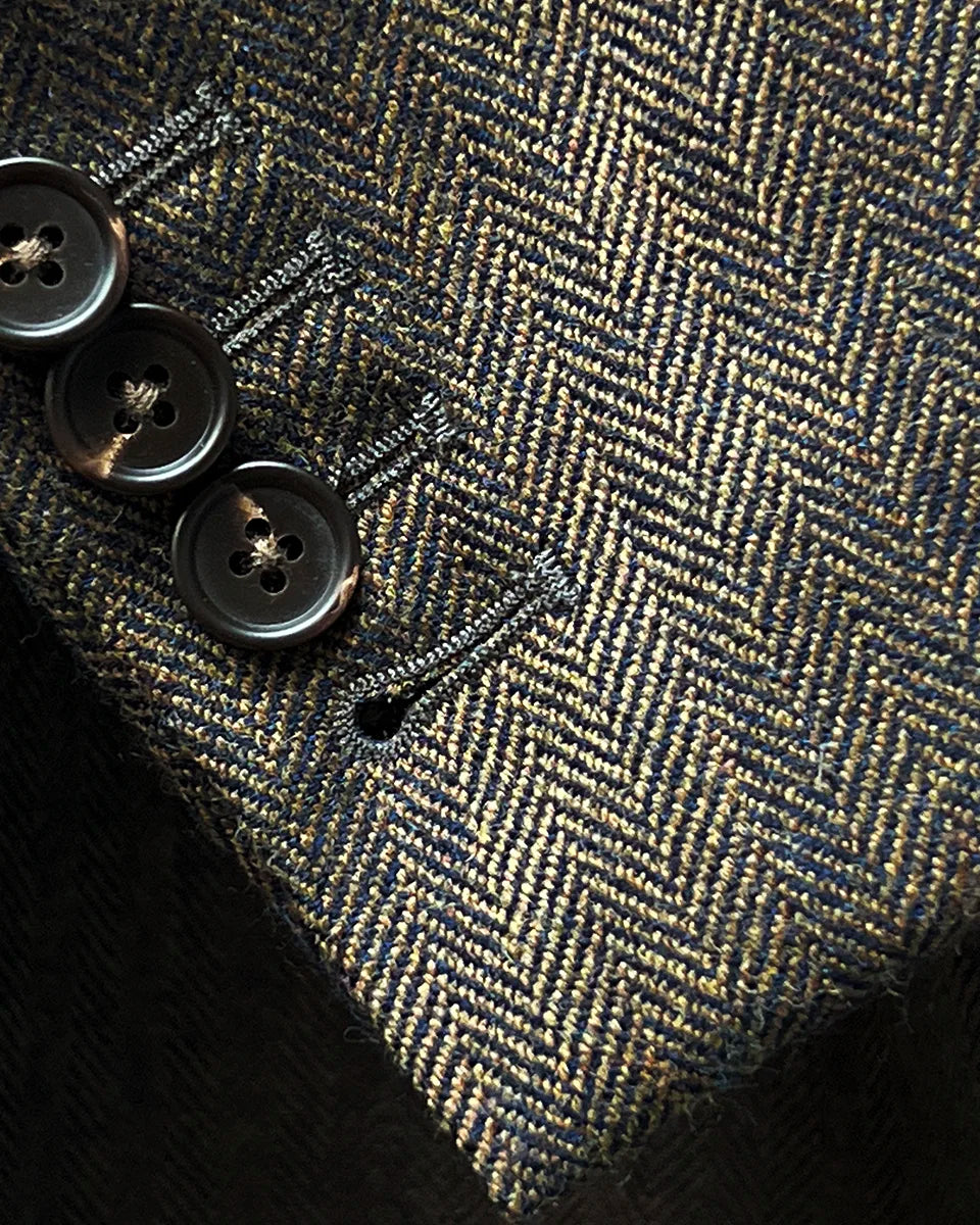 Working sleeve buttonholes detail demonstrating authentic tailoring with functional walnut brown horn buttons on jacket cuff