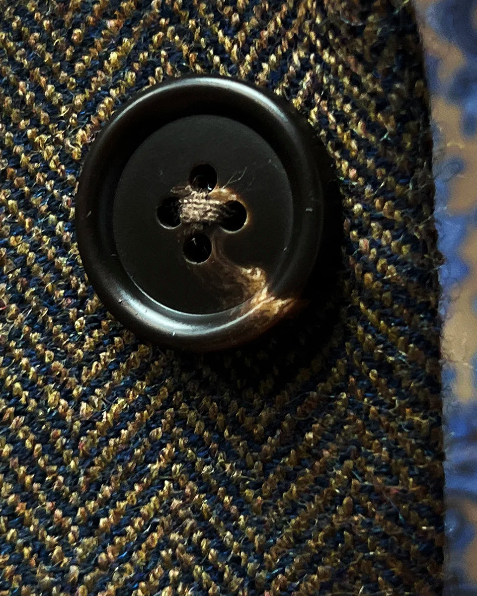 Close-up of premium walnut brown horn buttons displaying natural marble patterns and artisanal quality
