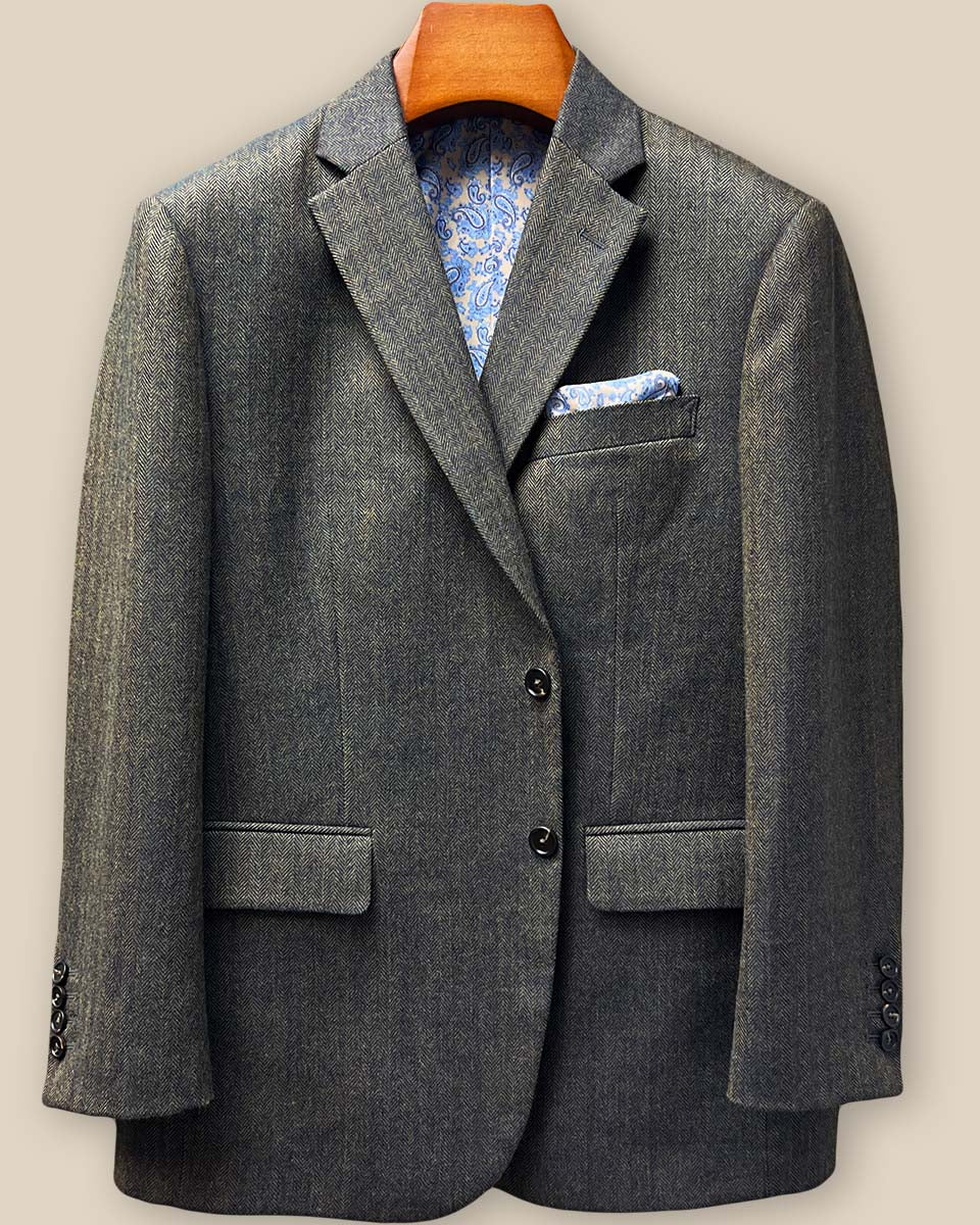 Front button stance showing walnut horn buttons against herringbone weave with lapel roll and chest pocket positioning