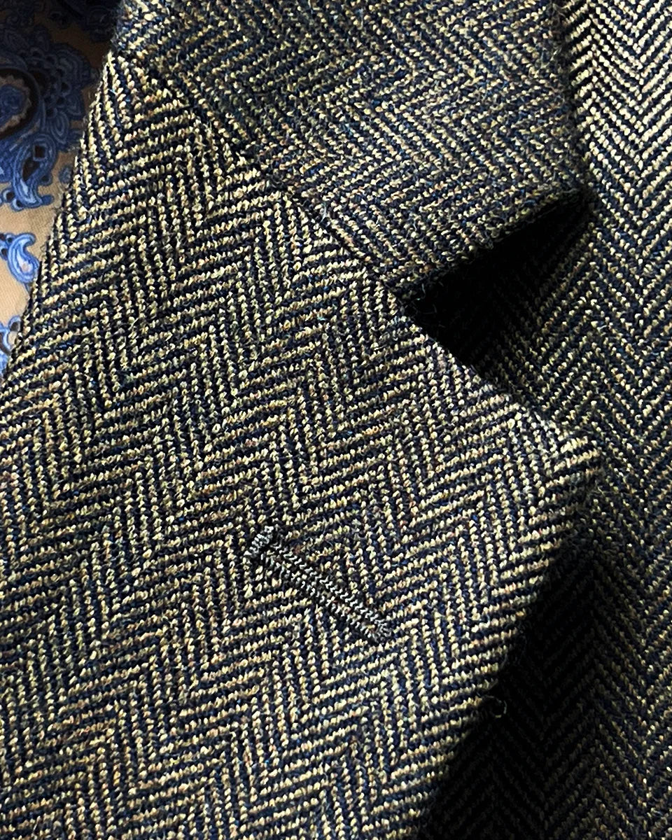 Classic notch lapel detail showing proper proportions, gorge placement, and herringbone pattern flow across lapel construction
