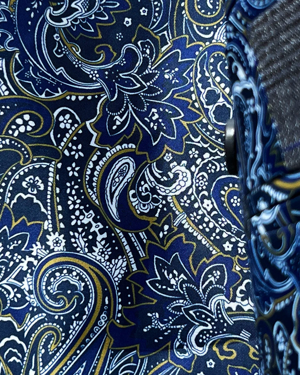 Close-up of the vibrant blue paisley lining with gold and white accents visible when the jacket moves, adding a flash of personality to the conservative exterior