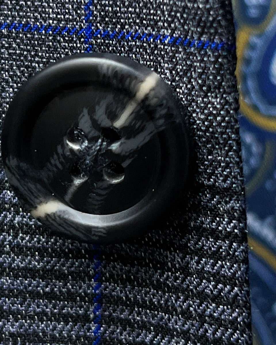 Macro shot of an unfastened grey marble horn button, revealing the natural patterns and depth of color in these premium suit fastenings