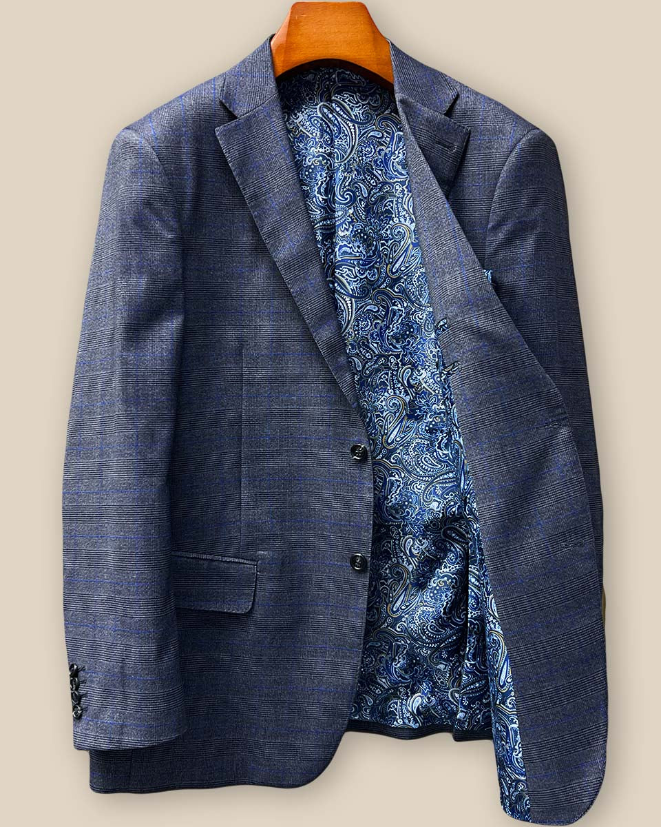 Interior view of the left side of the custom suit jacket revealing the luxurious blue paisley lining with gold and white accents, plus an accessible interior pocket perfect for business cards