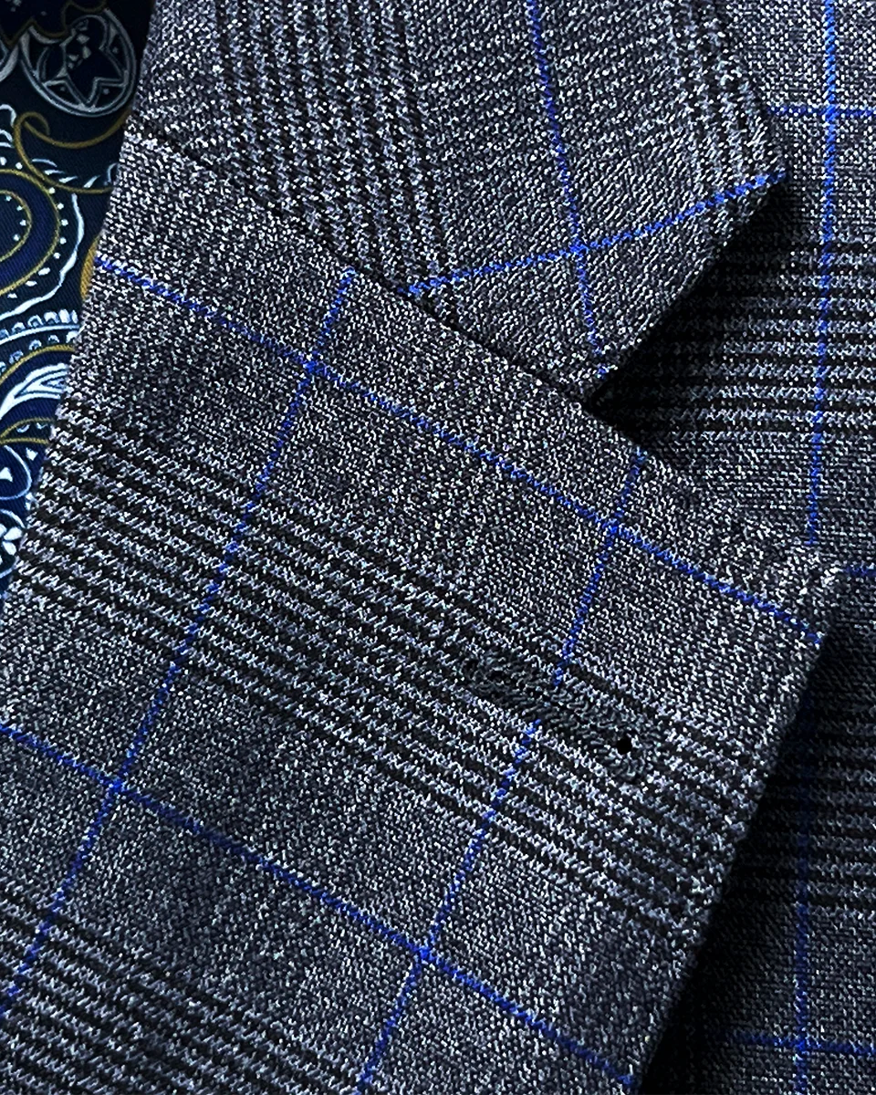 Detailed view of the classic notch lapel on the medium grey suit jacket with visible pick stitching, showing the clean lines and balanced proportions