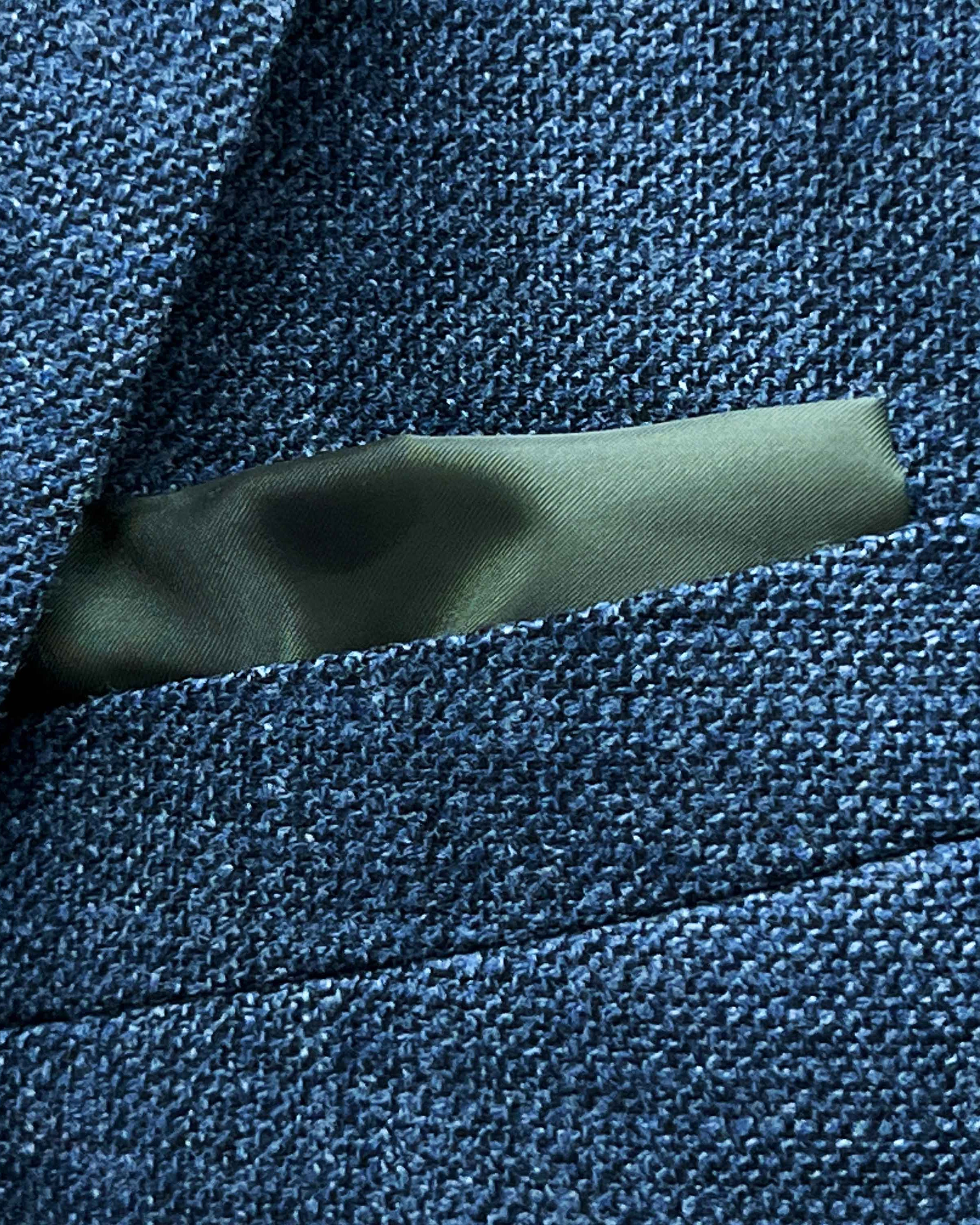 Breast pocket of medium steel blue hopsack sport coat with built-in pocket square holder and hand-finished edges