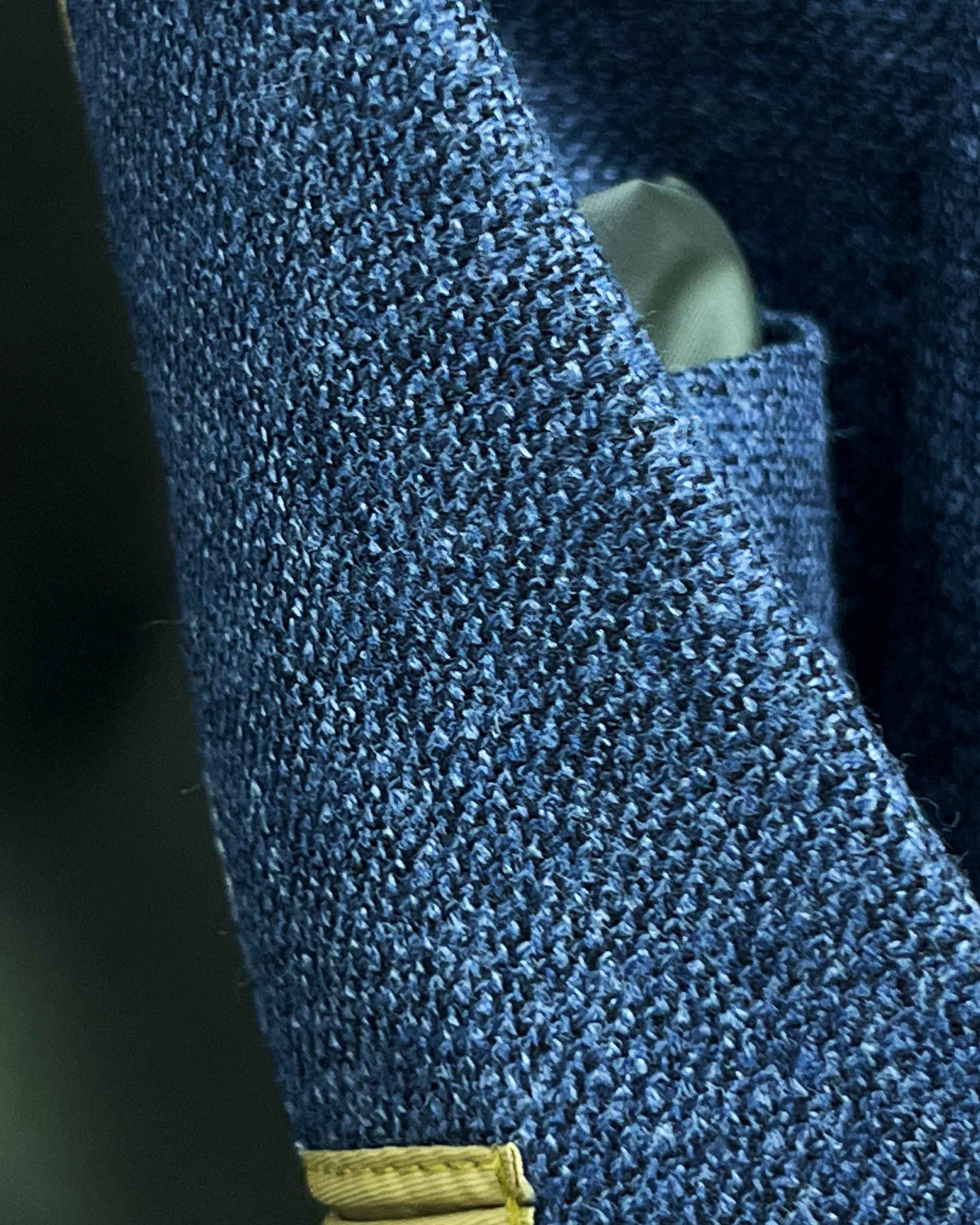Close-up of medium steel blue hopsack weave fabric texture showing distinctive basket weave pattern and melange effect