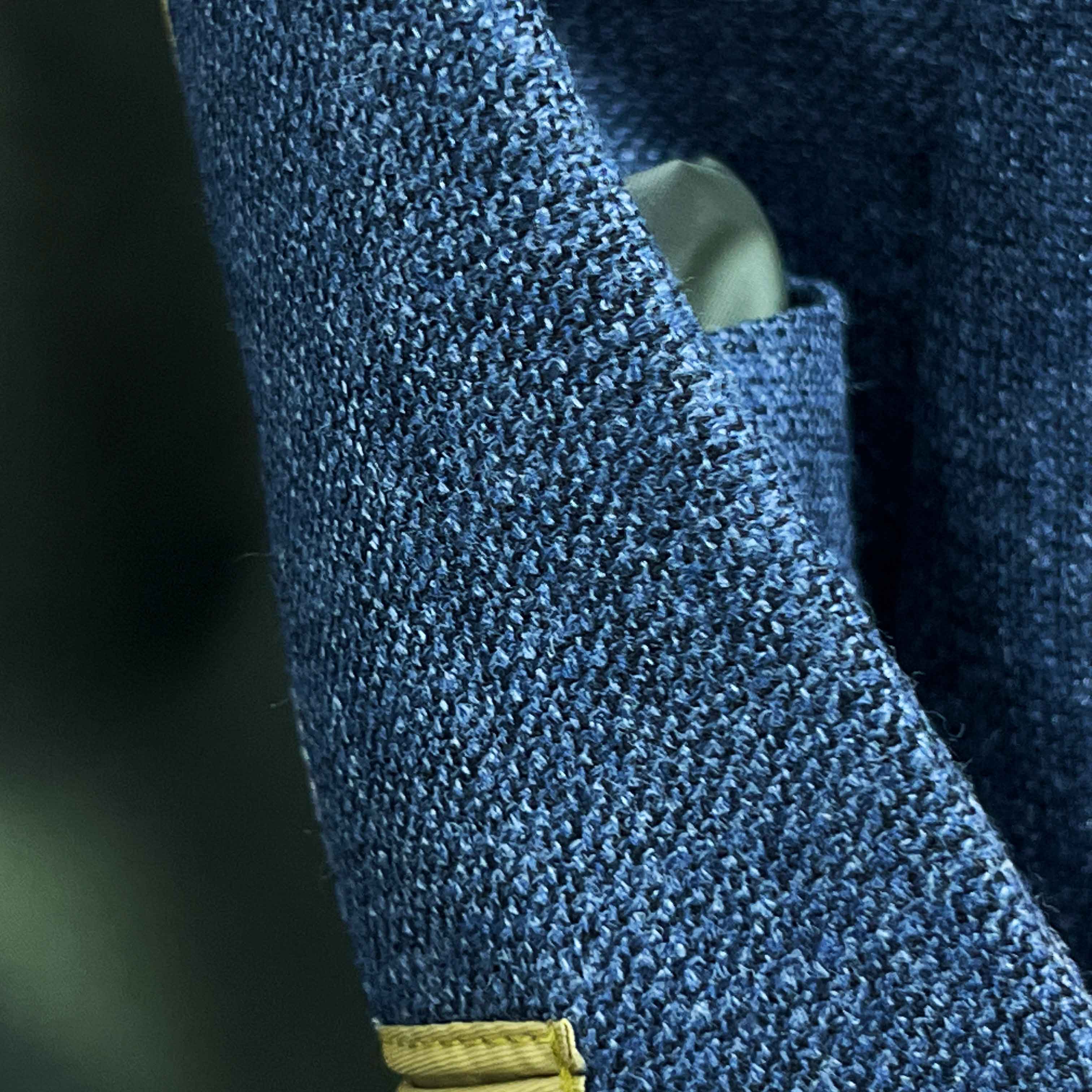 Close-up of medium steel blue hopsack weave fabric texture showing distinctive basket weave pattern and melange effect