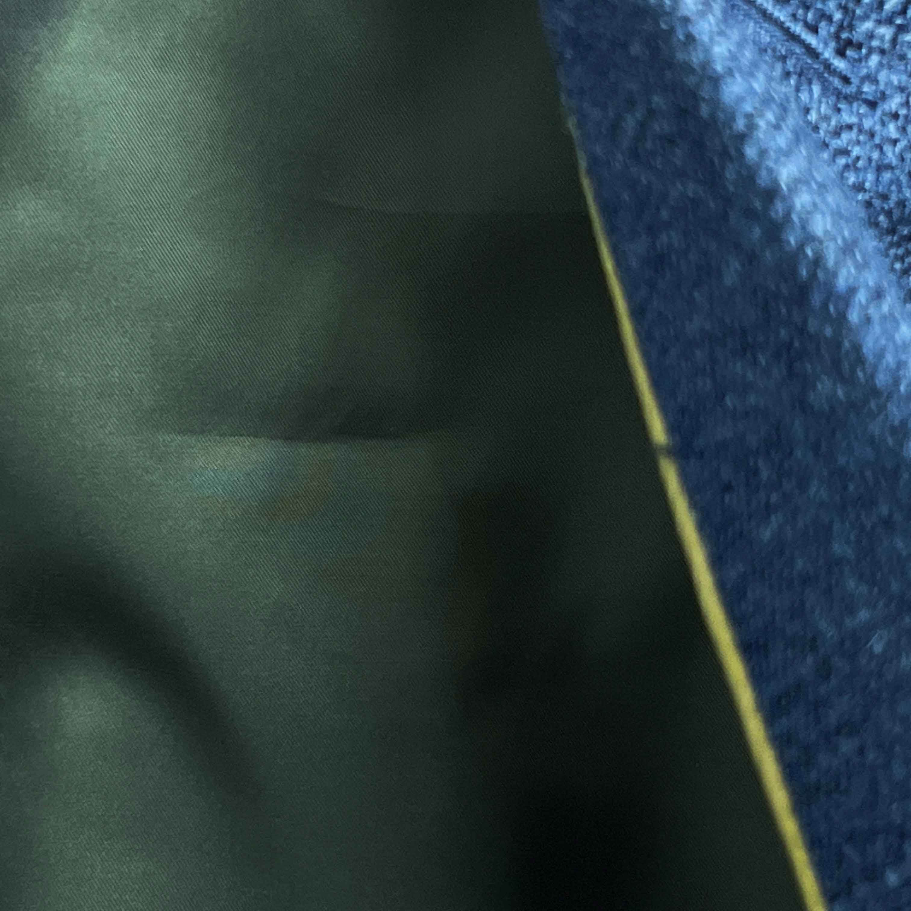 Olive green flash lining detail visible at jacket cuffs and vents in bemberg silk