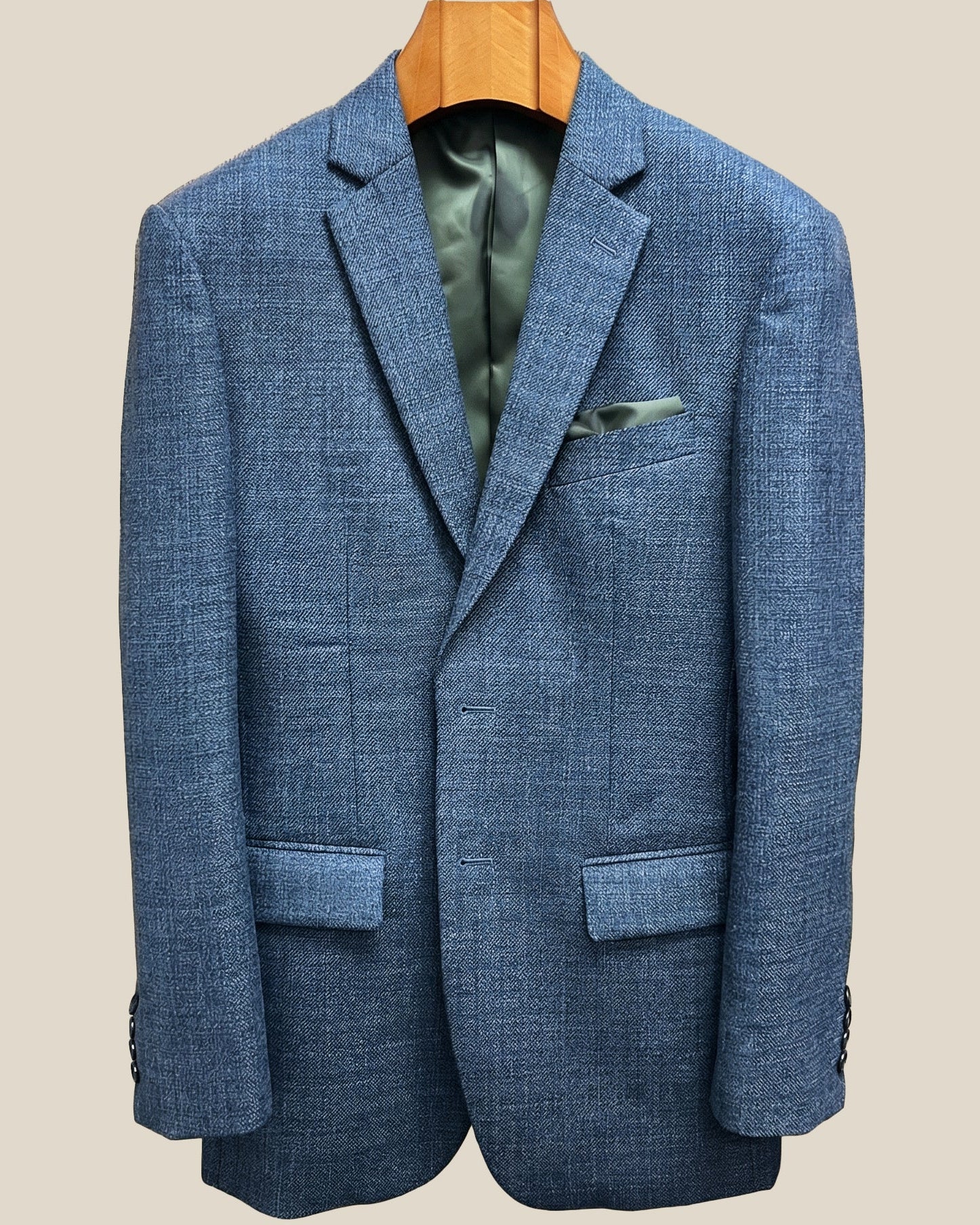 Close-up view of medium steel blue hopsack sport coat showing olive green contrast accent buttonhole with hand-finished stitching detail