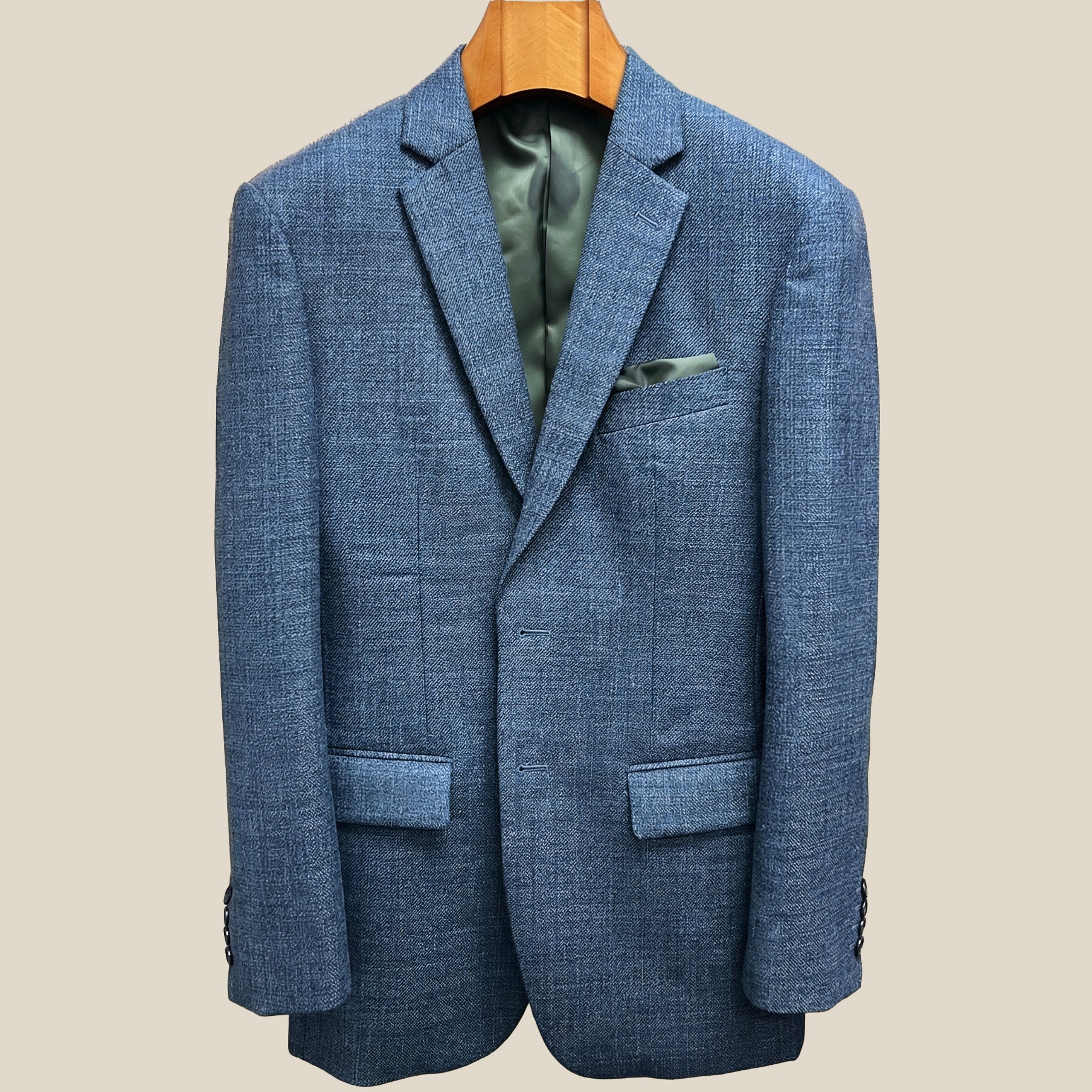 Close-up view of medium steel blue hopsack sport coat showing olive green contrast accent buttonhole with hand-finished stitching detail
