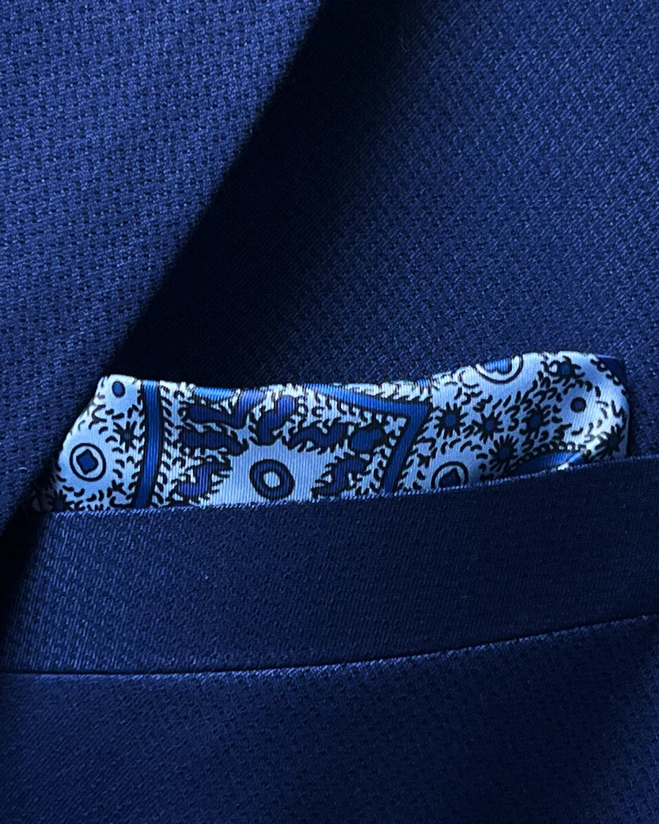 Breast pocket of navy blue geometric textured suit jacket with built-in pocket square holder and hand-finished edges