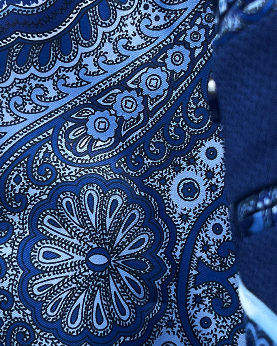 Colorful flash lining detail visible at jacket cuffs and vents in rich blue intricate paisley pattern