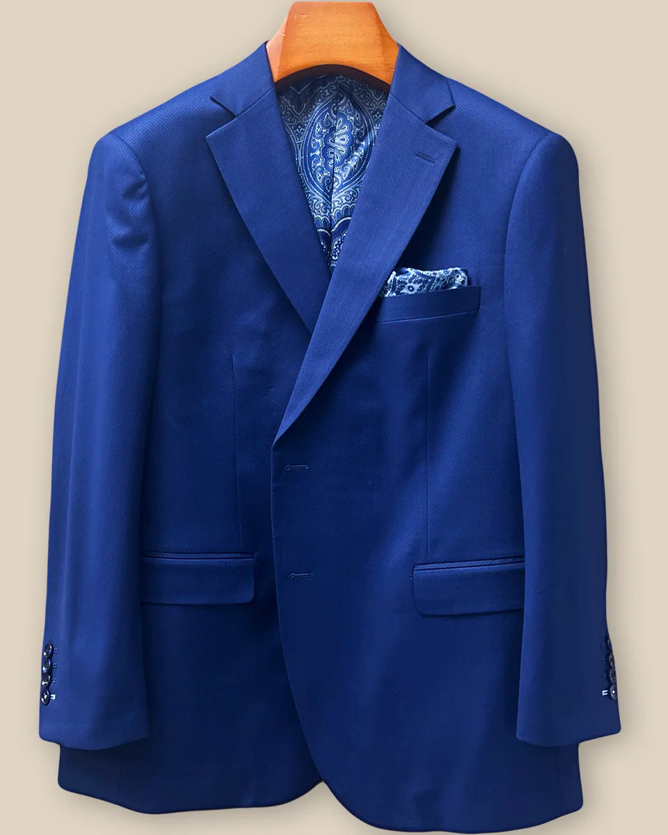 Close-up view of navy blue geometric textured suit jacket showing contrast light blue accent buttonhole with hand-finished stitching detail