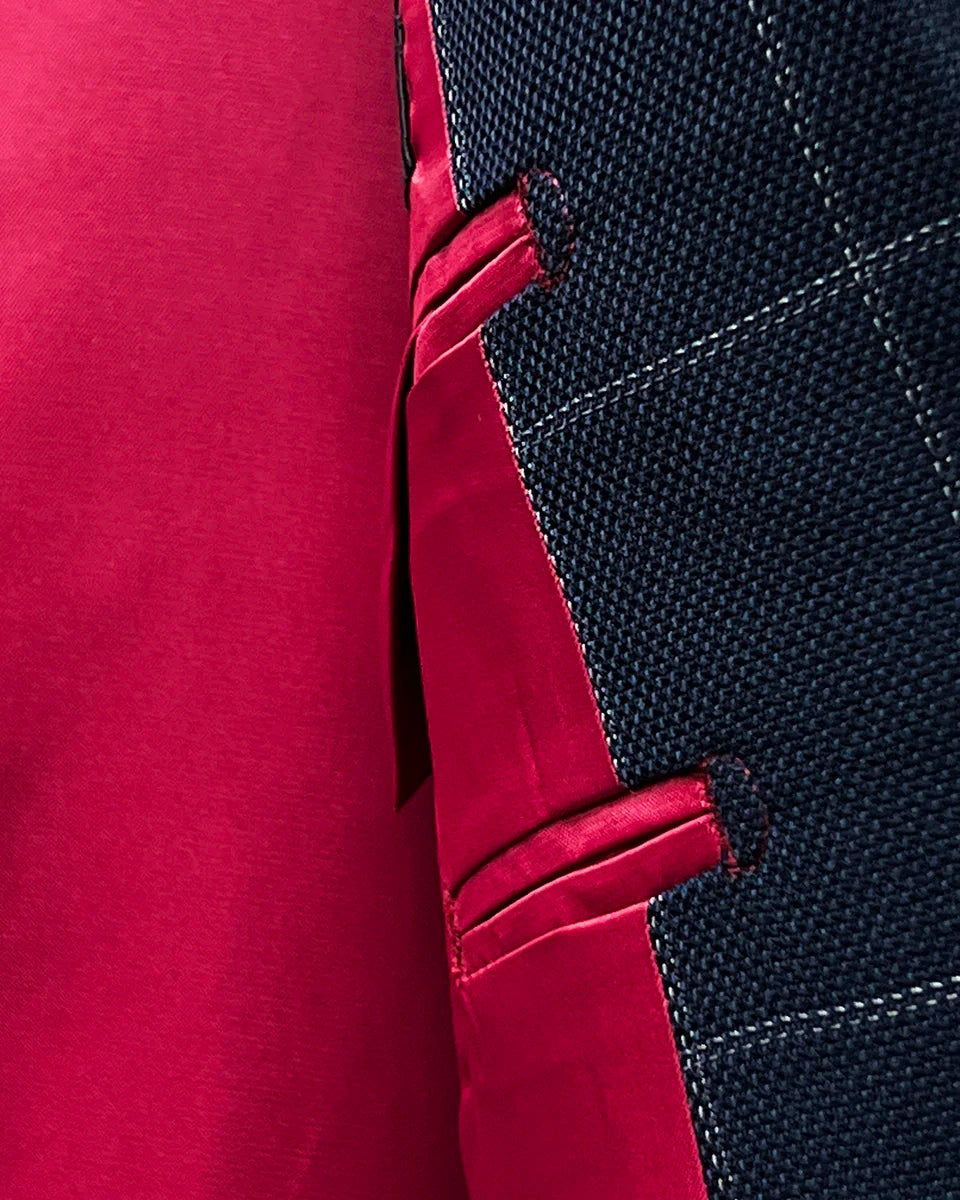 Close-up texture shot of tomato red silk bemberg lining used in navy windowpane suit