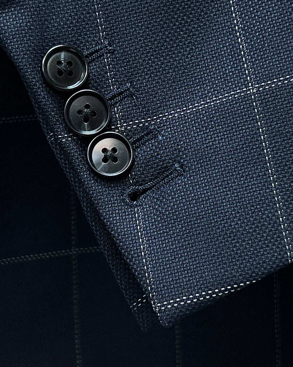 Detail shot of functional buttonholes on suit jacket sleeve, showcasing fine stitching
