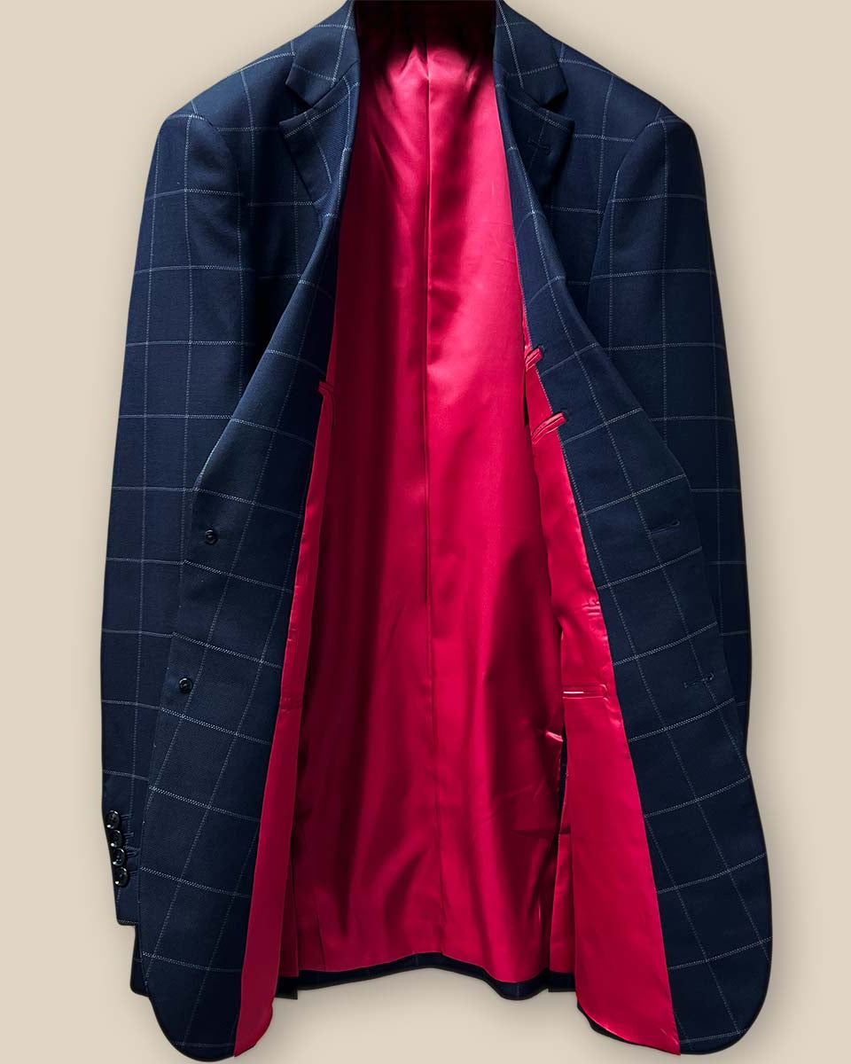 Full interior view of navy windowpane suit jacket, showcasing vibrant tomato red silk bemberg lining