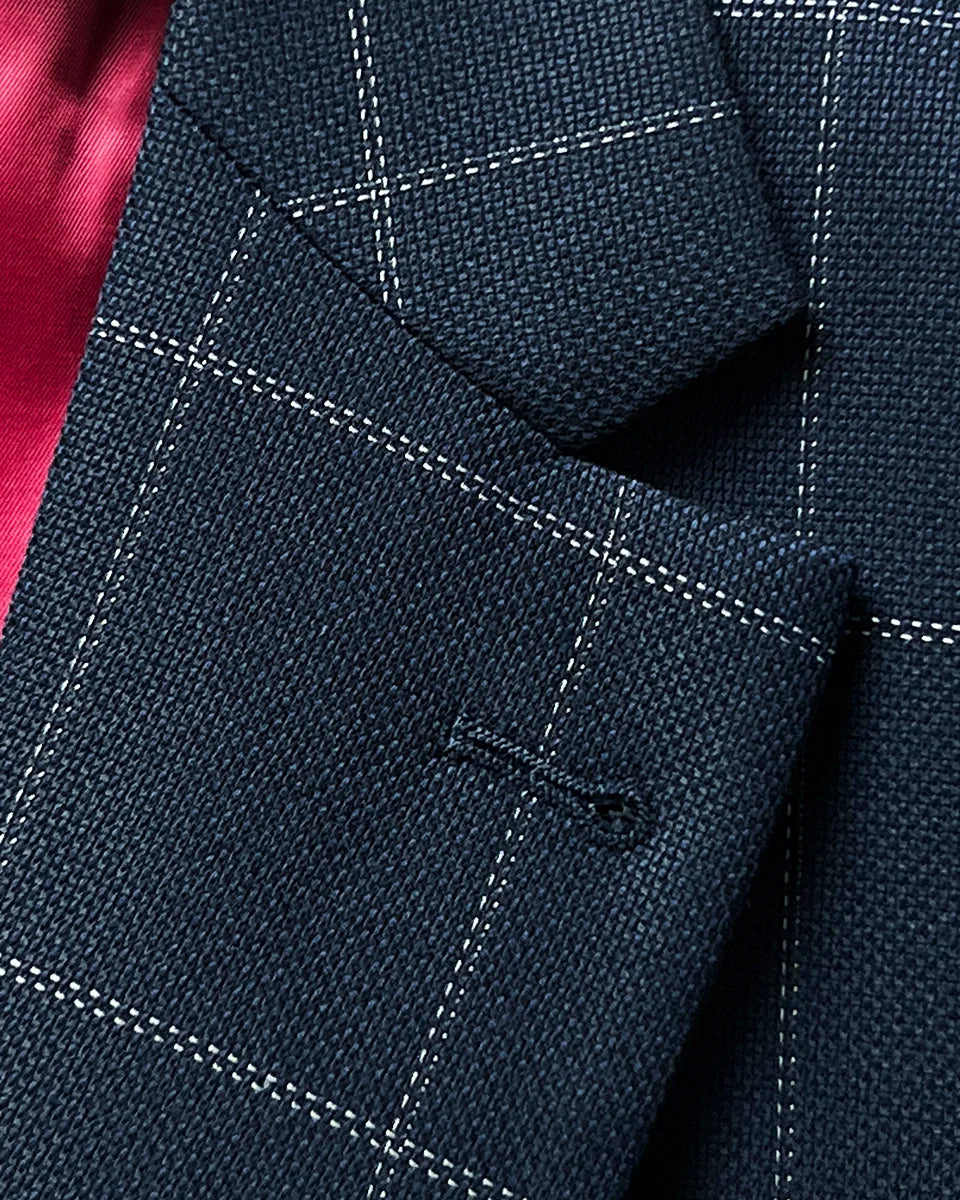 Detail of semi-notch lapel on navy windowpane suit jacket, showing lapel roll and stitching