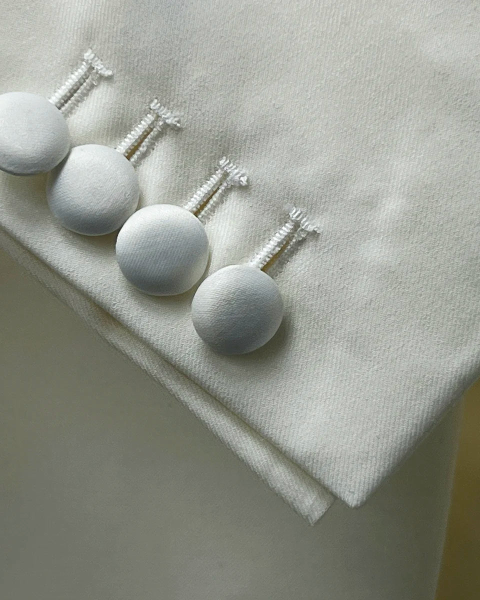 Detailed view of the Westwood Hart dinner jacket cuff showing functional sleeve buttonholes with off-white silk satin covered buttons