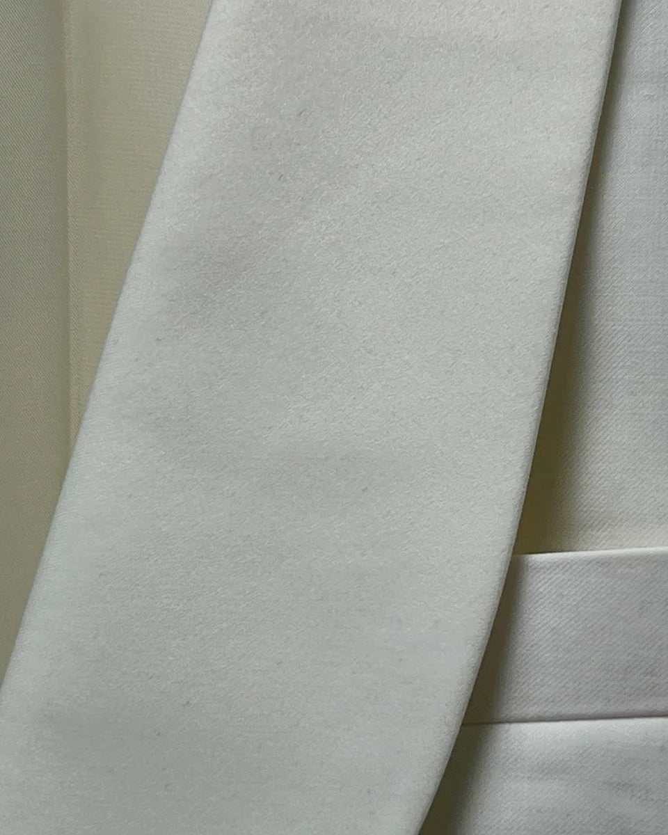 Detailed view of the Westwood Hart dinner jacket's elegant off-white silk satin shawl lapel, showcasing its smooth curve and lustrous finish