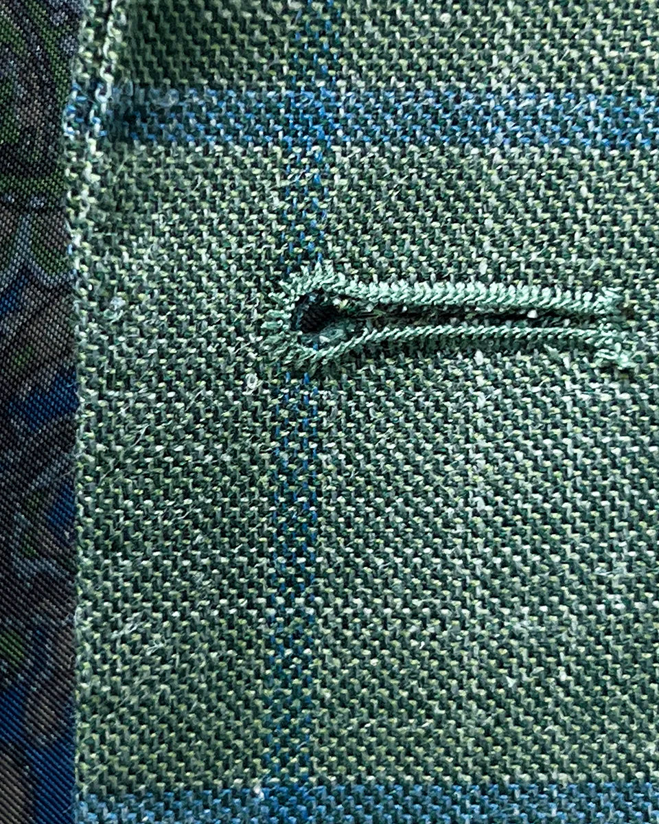 Macro detail of royal blue contrast buttonhole stitching technique showing hand-finished edges and precision thread work