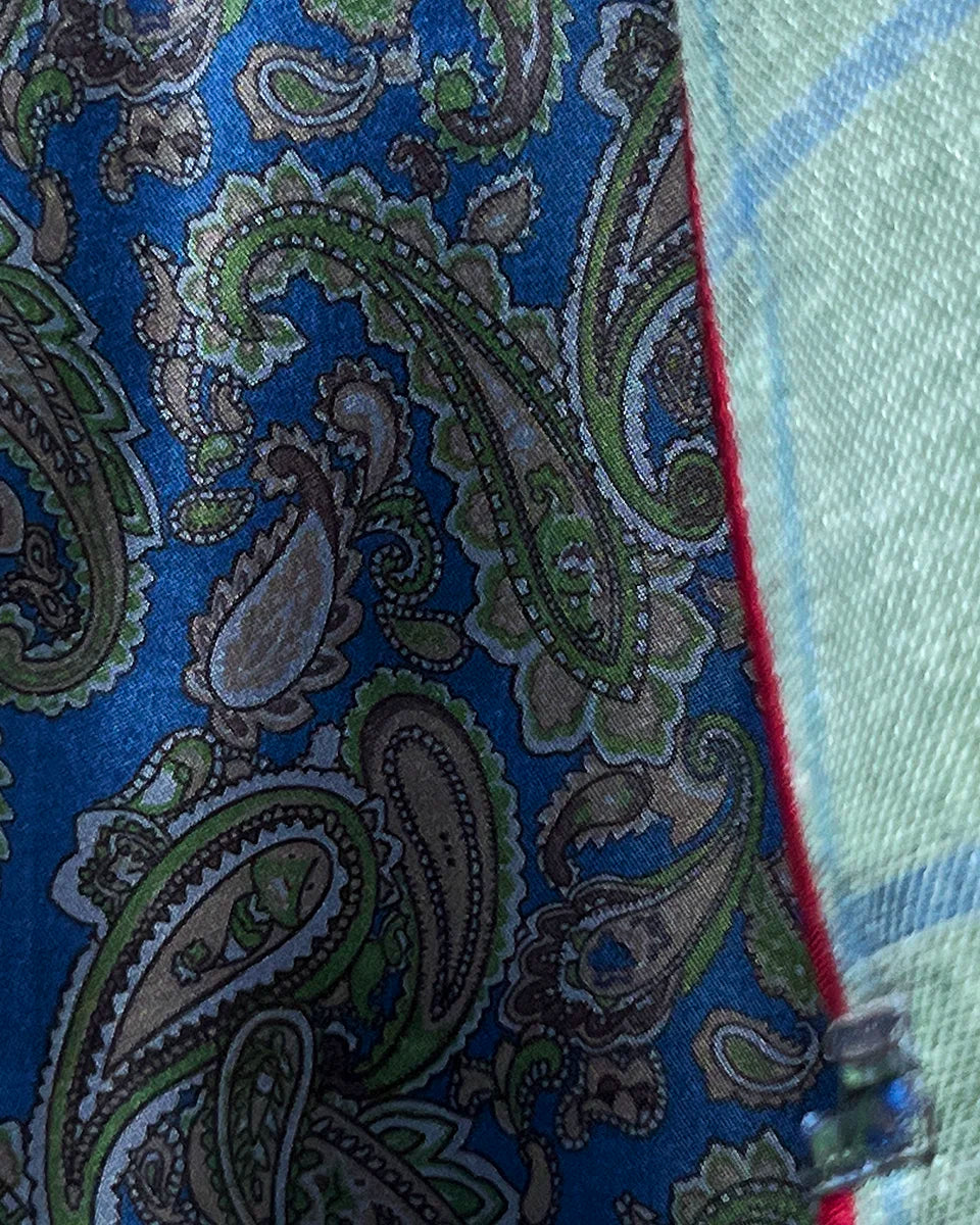 Dramatic flash lining reveal showing vibrant blue paisley pattern with maroon piping as jacket moves during wear