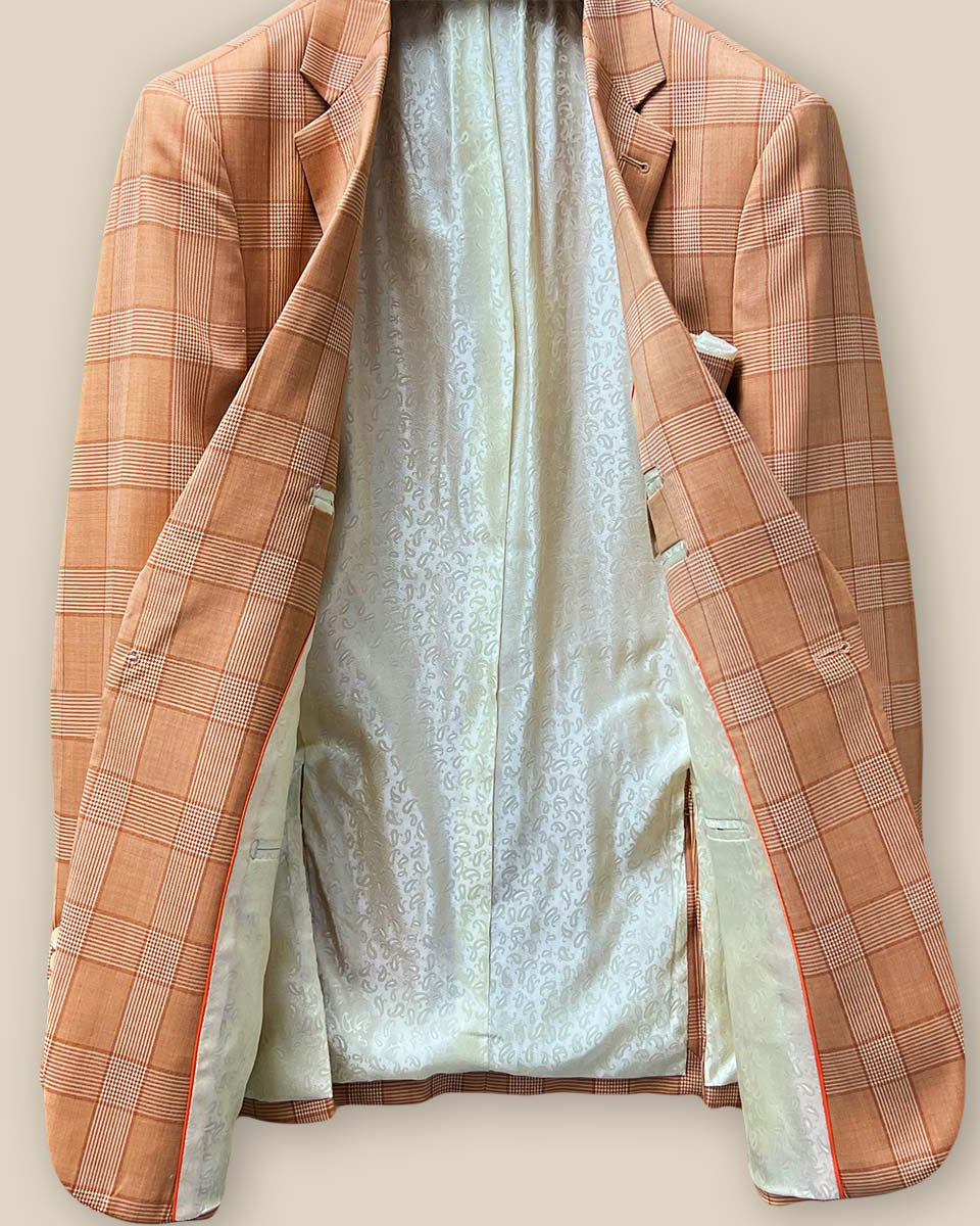 Full interior view of orange suit jacket displaying ivory paisley flash lining and tailoring details