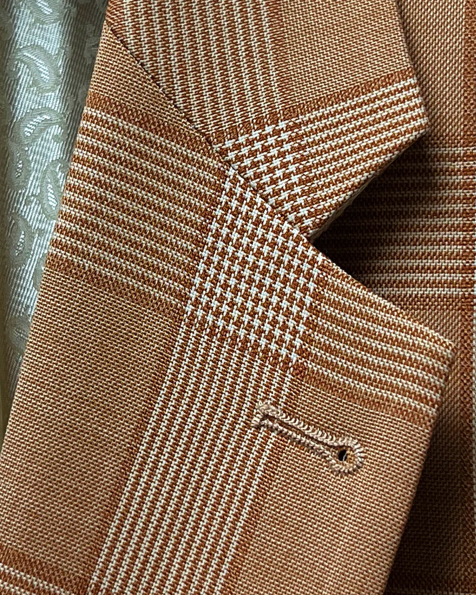 Detail of suit jacket's notch lapel, showcasing the Prince of Wales glen plaid pattern