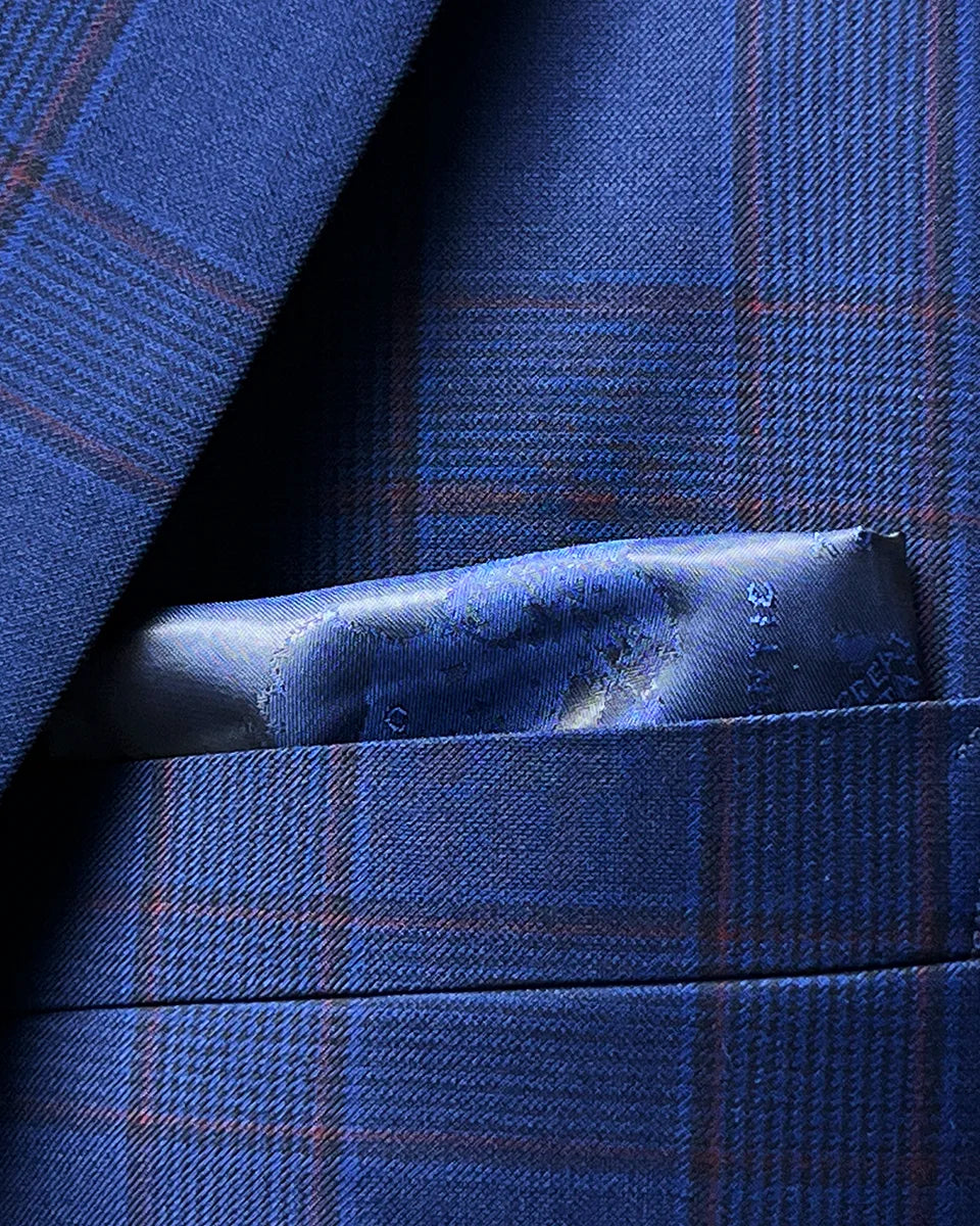 Integrated pocket square detail complementing the Prince of Wales plaid pattern with coordinated color scheme