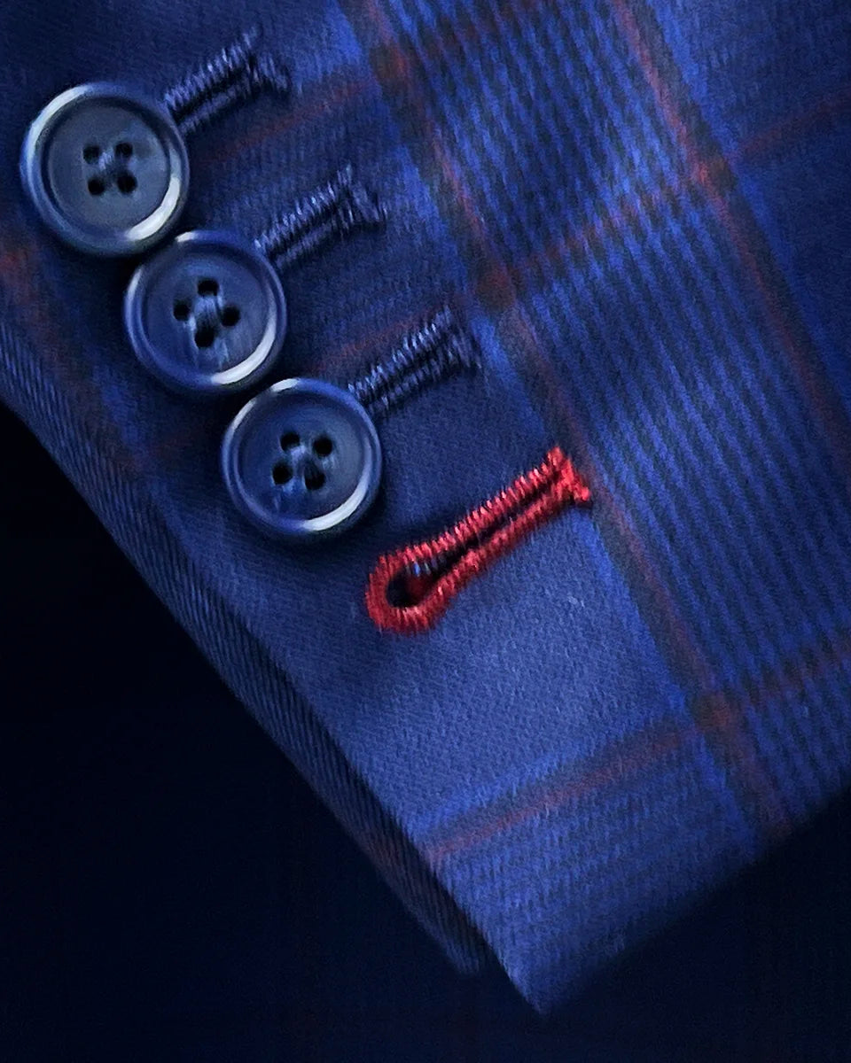 Close-up of functional sleeve buttonholes featuring crimson red contrast stitching detail on Super 140s merino wool fabric