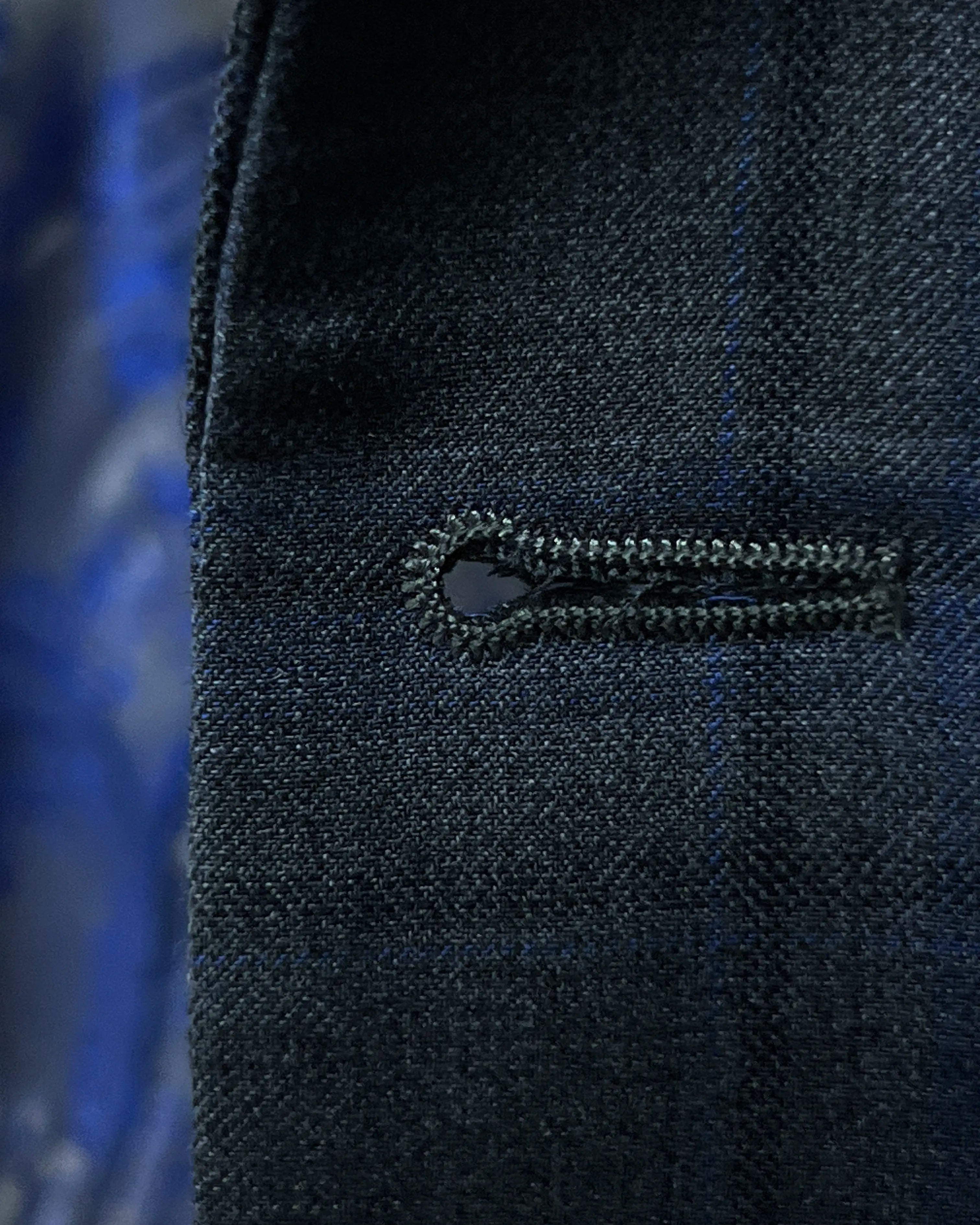 Front buttonhole detail of charcoal grey royal blue windowpane men's sport coat showing finish