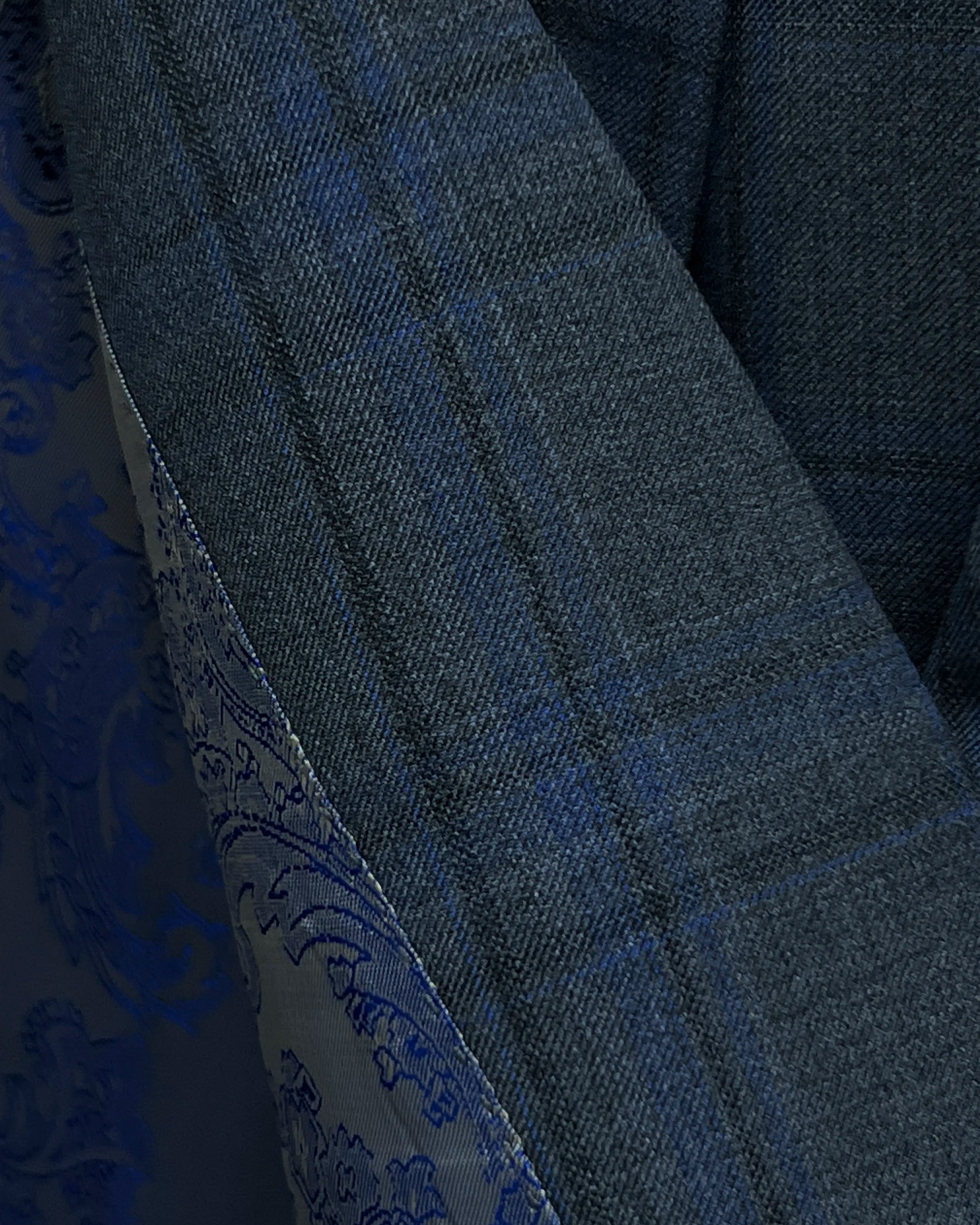 Fabric macro of charcoal grey royal blue windowpane men's sport coat showing fine twill texture