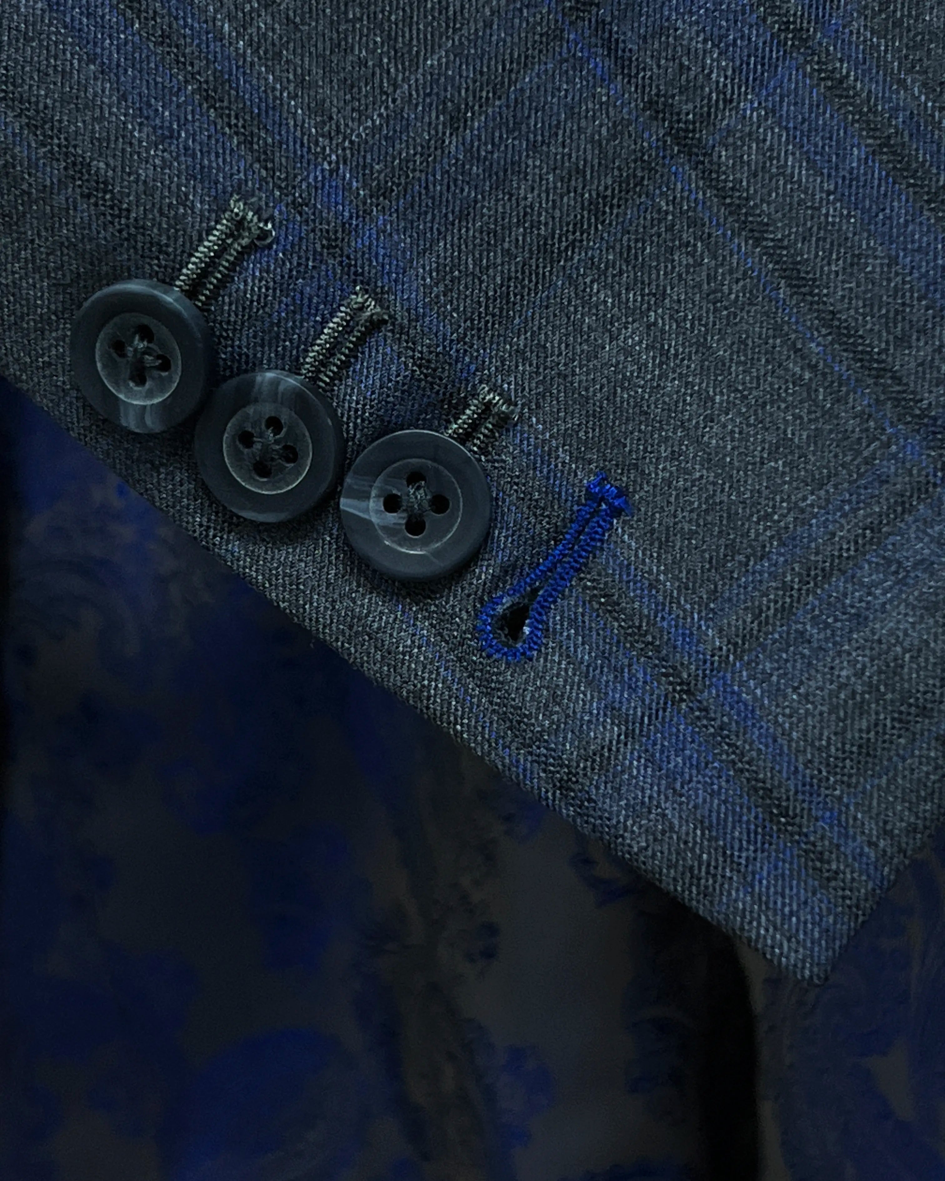 Sleeve cuff close up of charcoal grey royal blue windowpane men's sport coat showing functional buttons