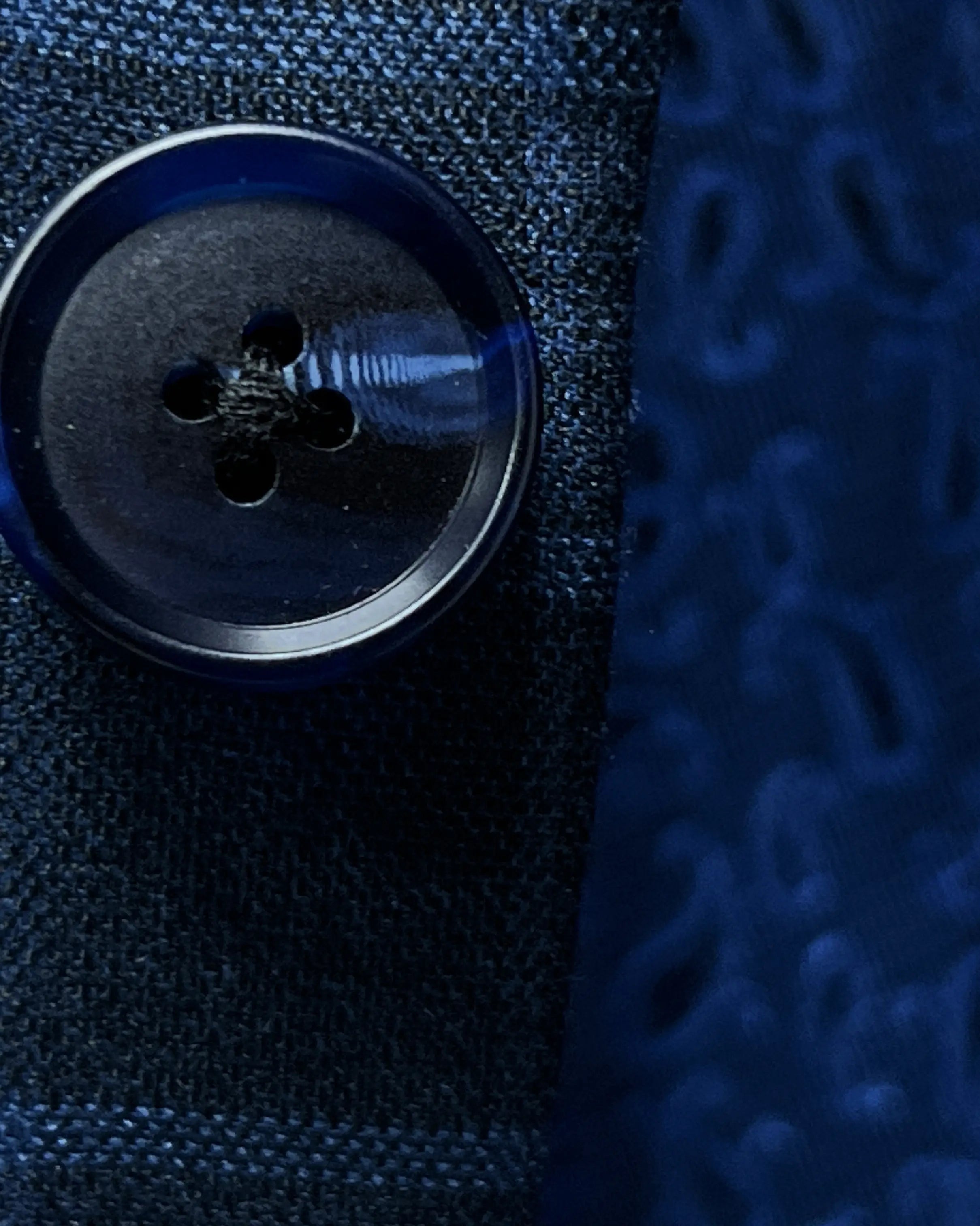 Button close up of slate blue windowpane check men's sport coat showing dark navy marble horn buttons