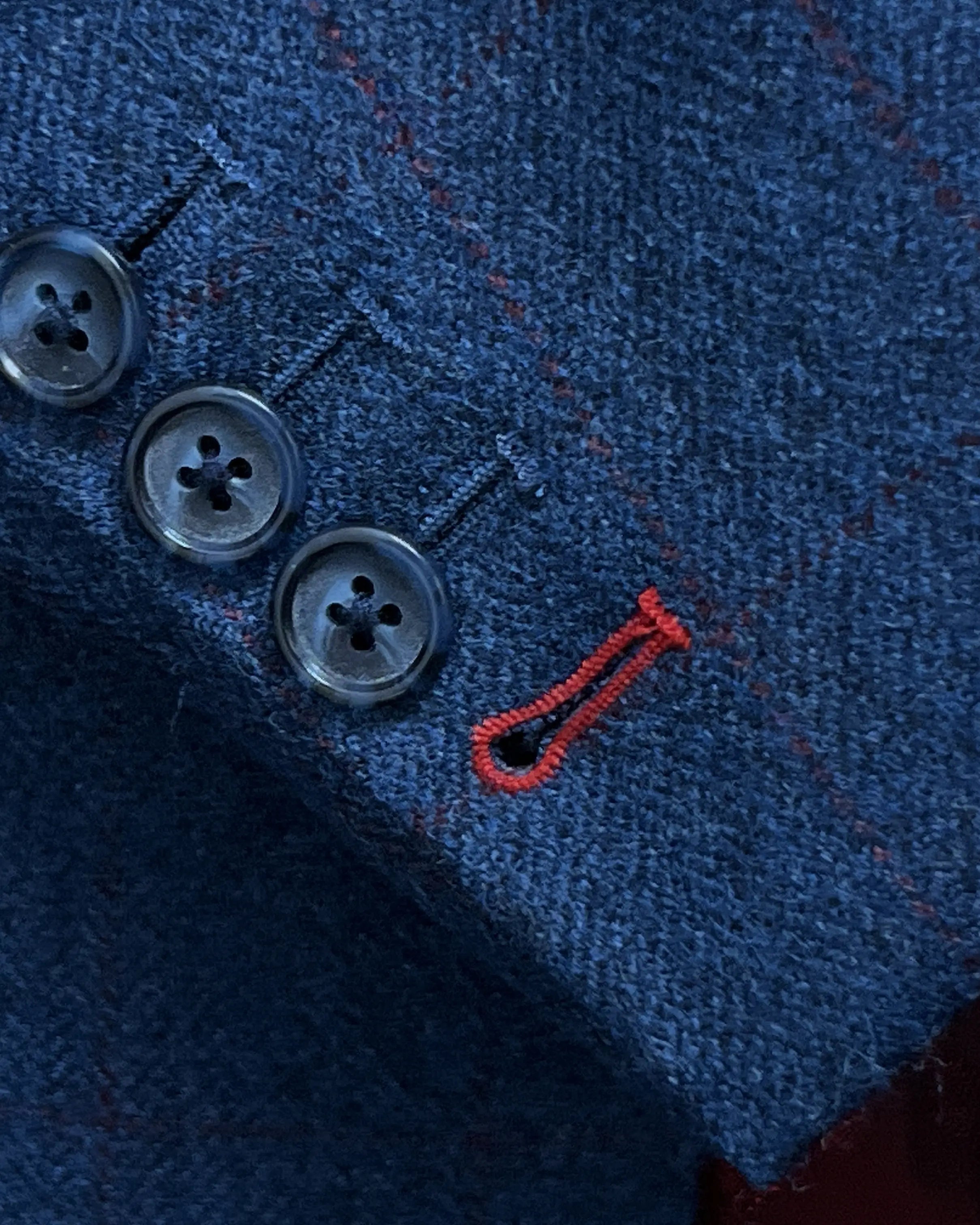 Sleeve cuff detail of teal blue with red windowpane men's sport coat showing the functional sleeve buttons