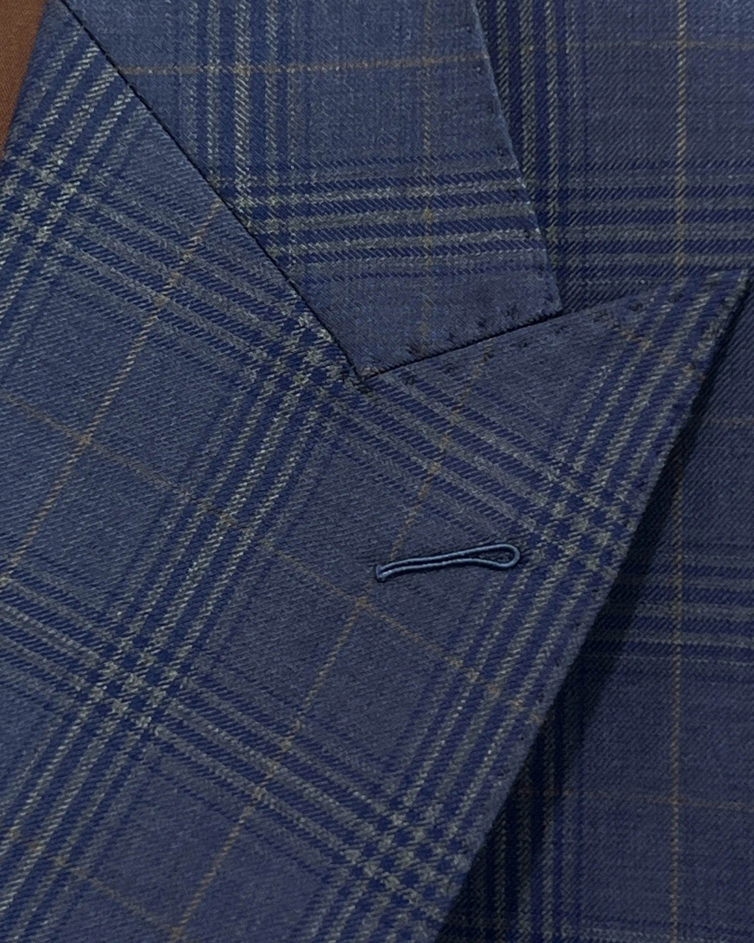 Lapel buttonhole detail of blue windowpane plaid men's suit showing standard lapel buttonhole stitching