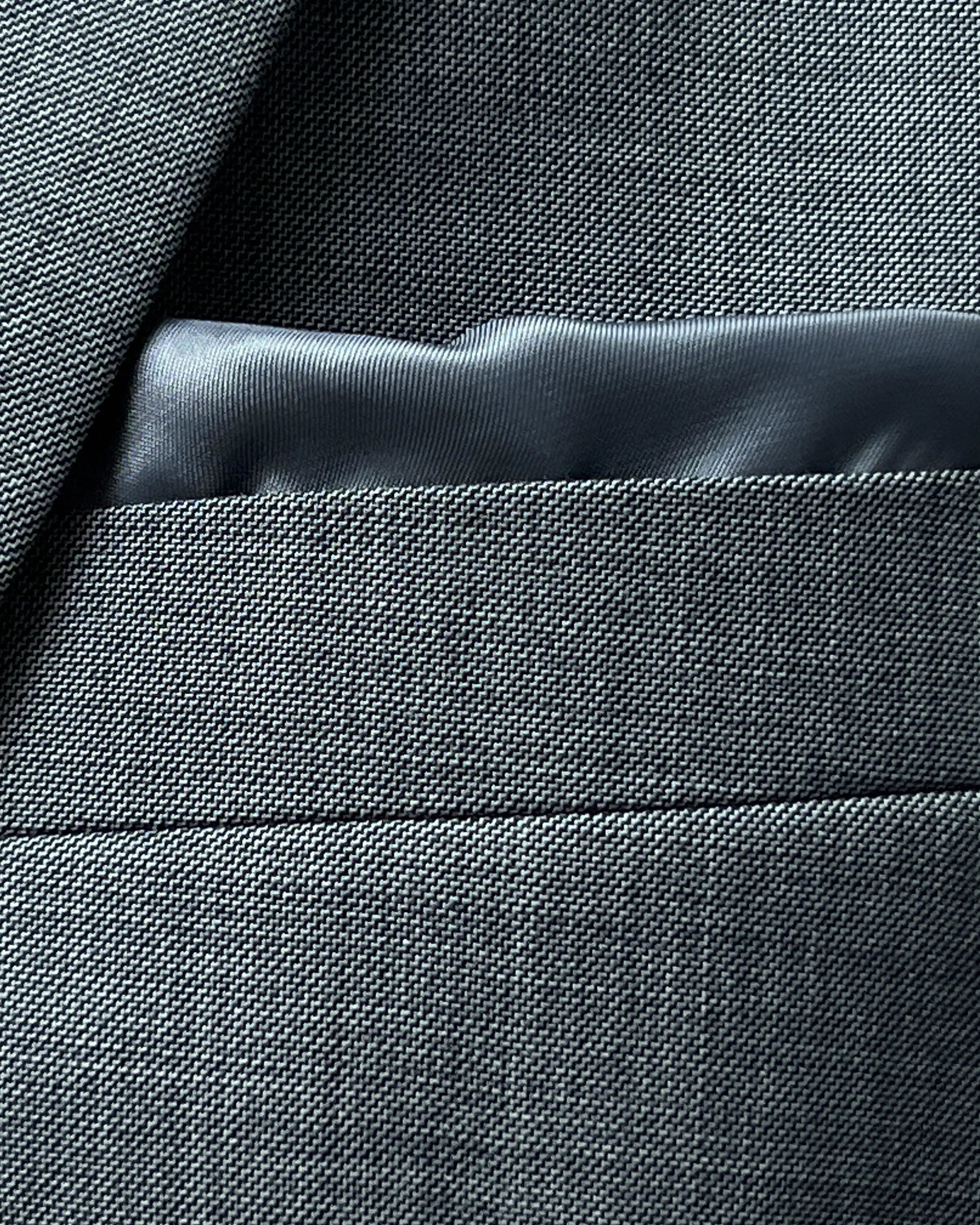Breast pocket close up of grey sharkskin men's suit showing built in lining pocket square
