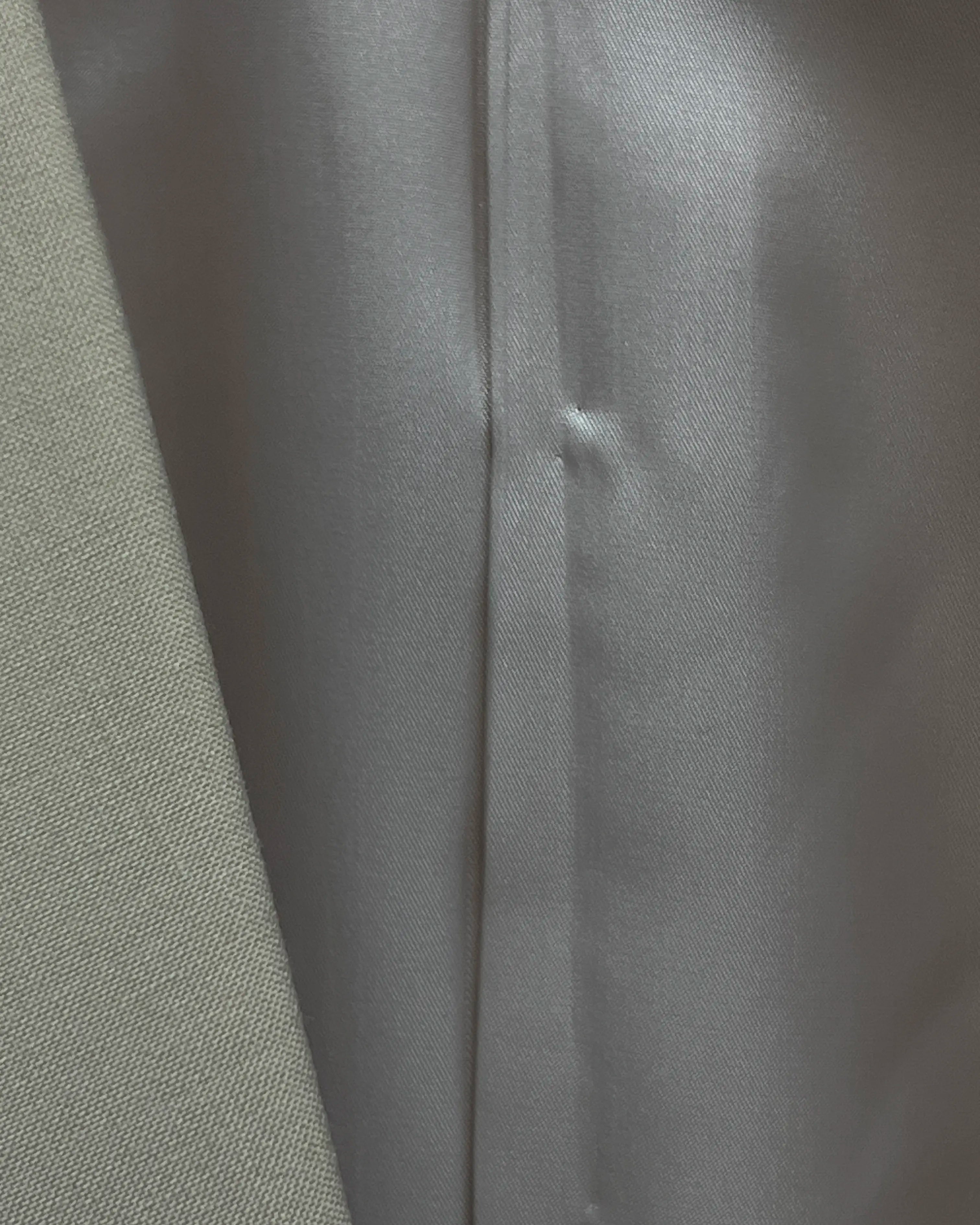 Lining close up of light beige plain men's suit showing smooth silver grey interior lining