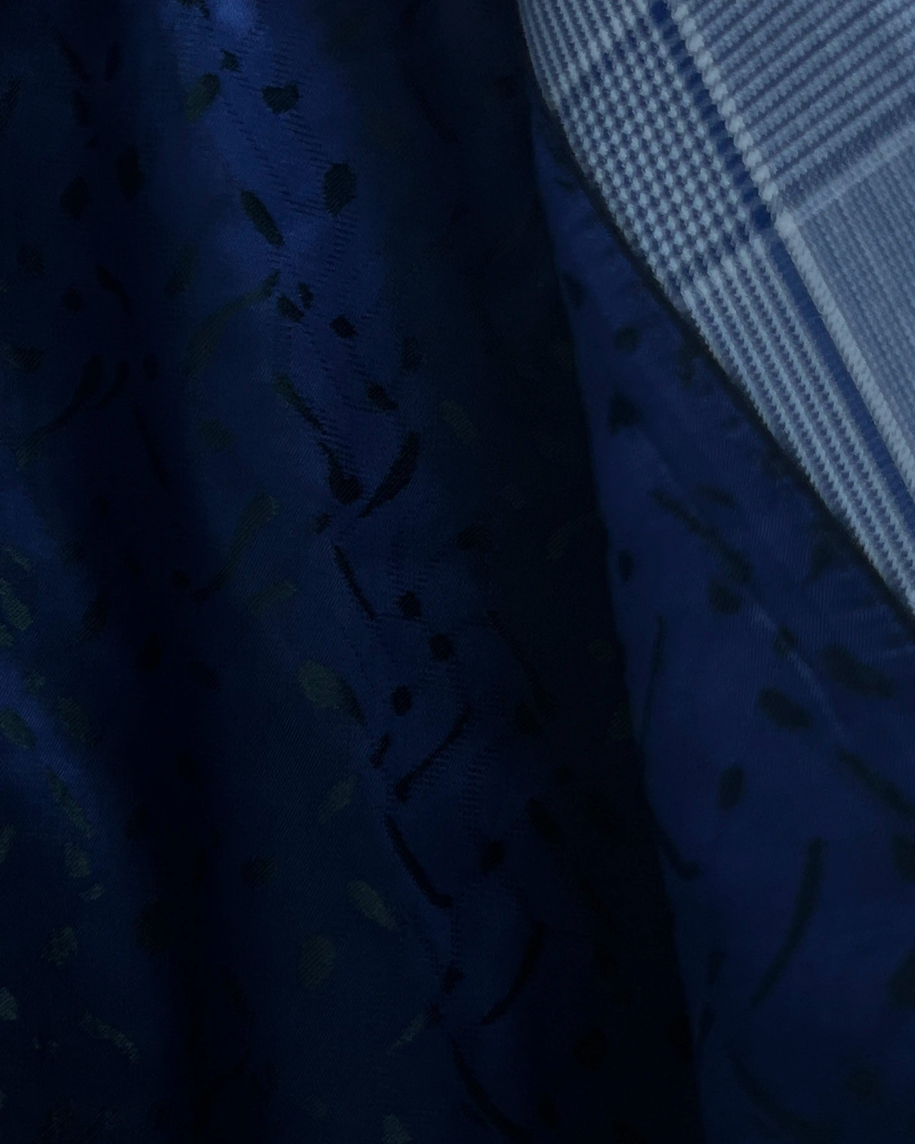 Lining close up of light blue Prince of Wales glen plaid with navy windowpane men's suit showing navy patterned Bemberg silk lining