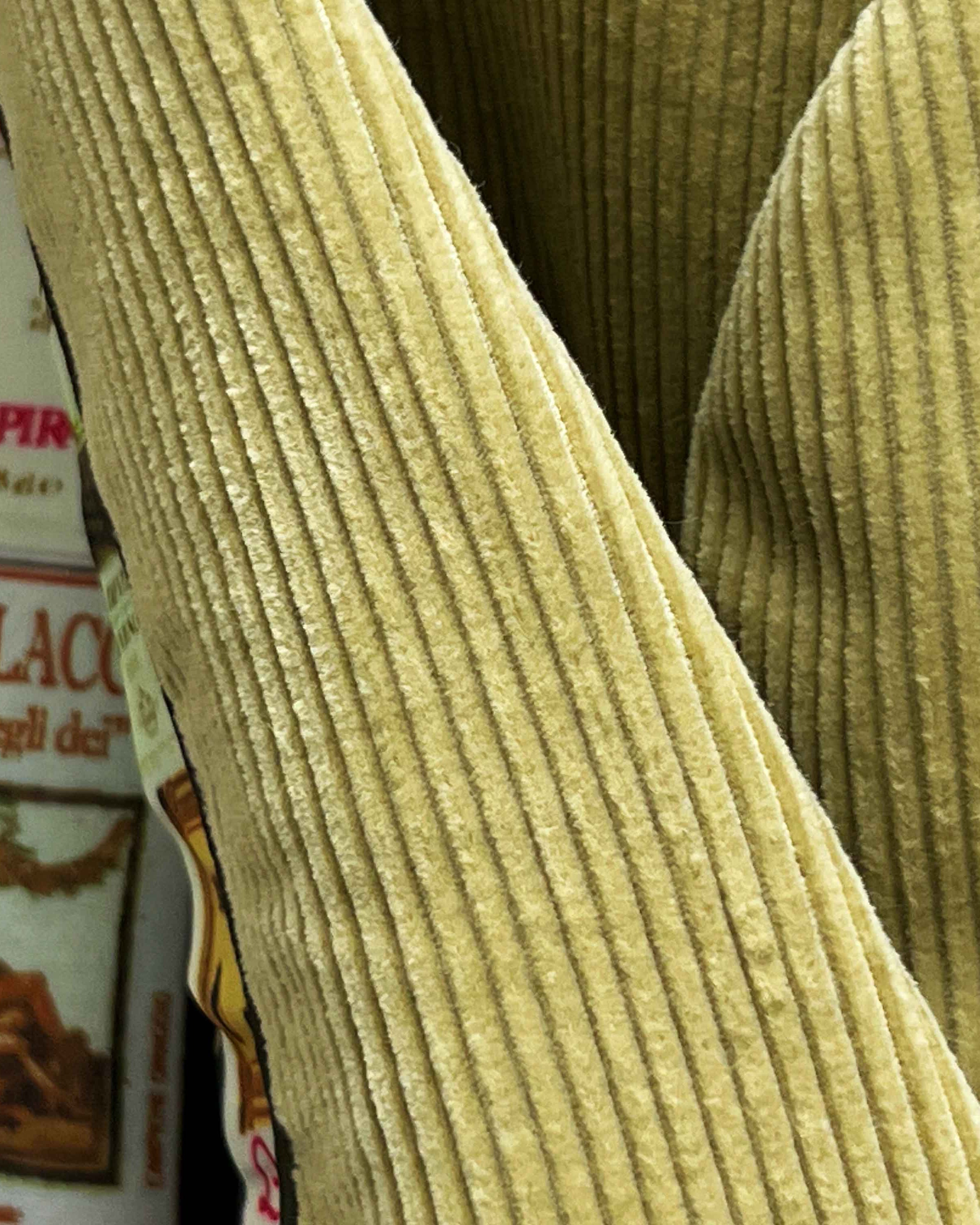 Close-up of 10-wale corduroy fabric texture on tan sport coat showing vertical ribbed pattern and soft pile